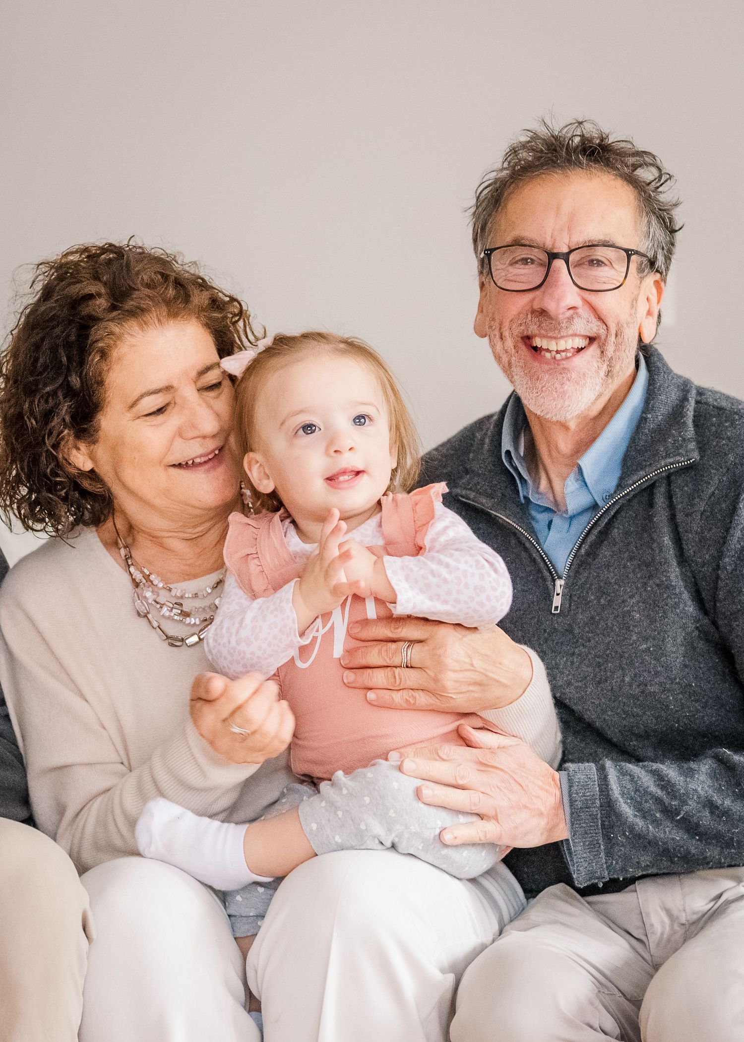 Three generations share a happy moment together during a family photo session.
