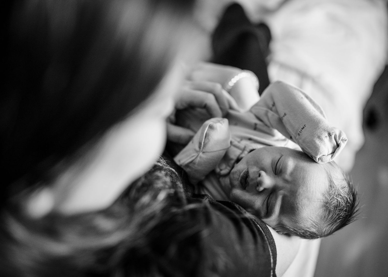 Black and white closeup of infant receiving a medical exam or checkup.