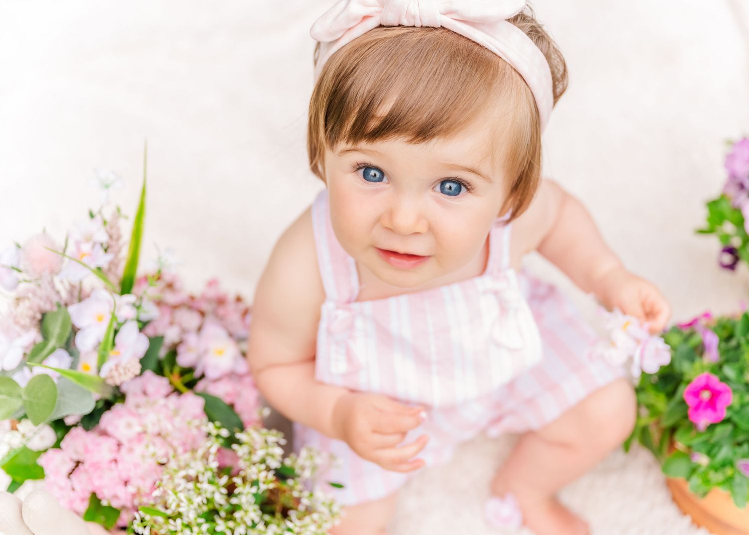 Spring garden scene with pink flowers and white decor.