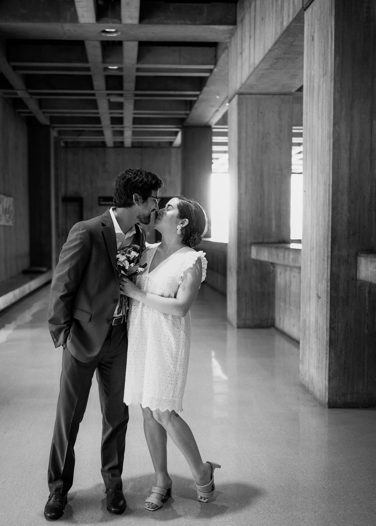 Wedding couple sharing an intimate moment in an industrial hallway.