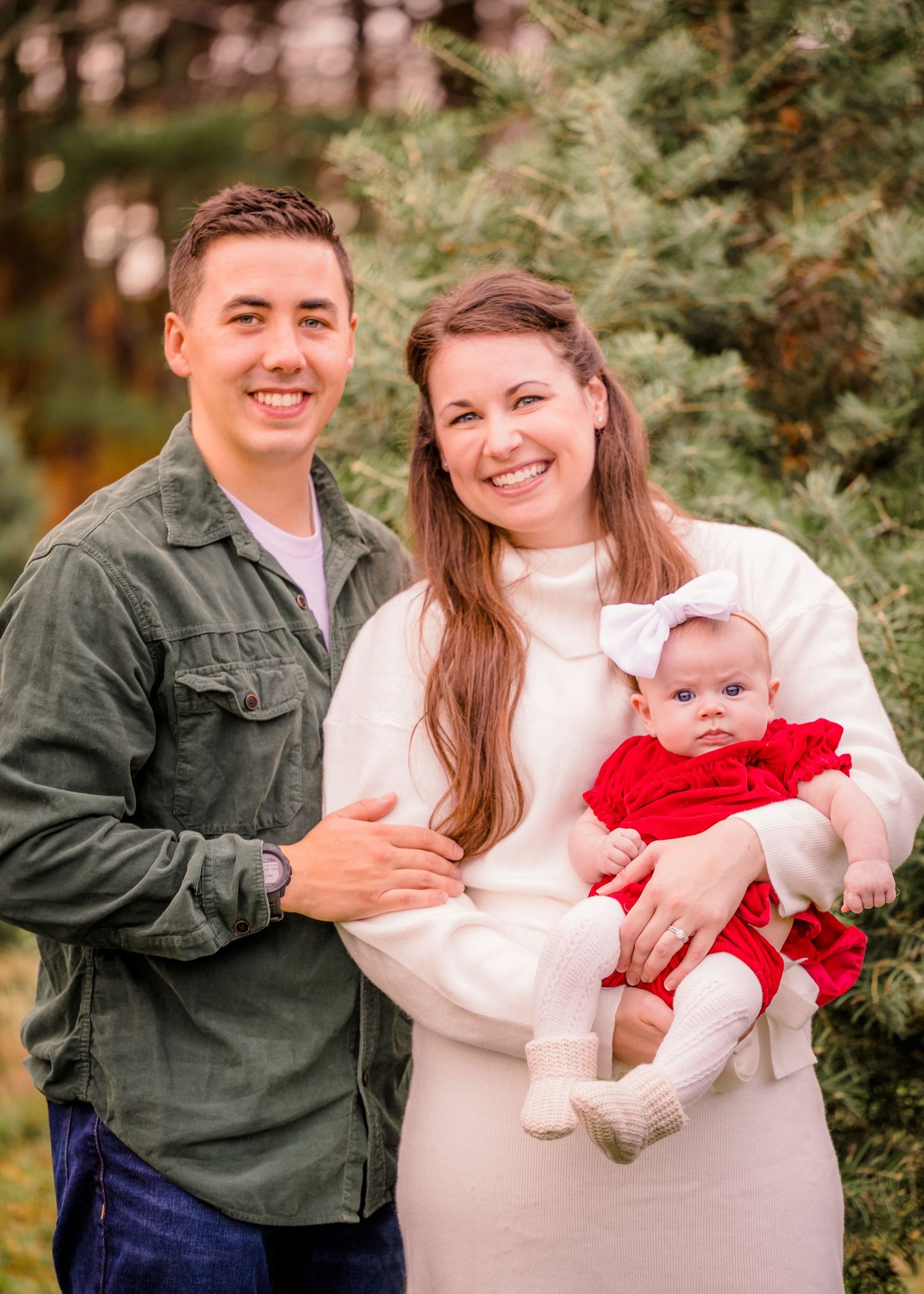 Heartwarming family portrait outdoors with everyone wearing coordinated winter outfits.