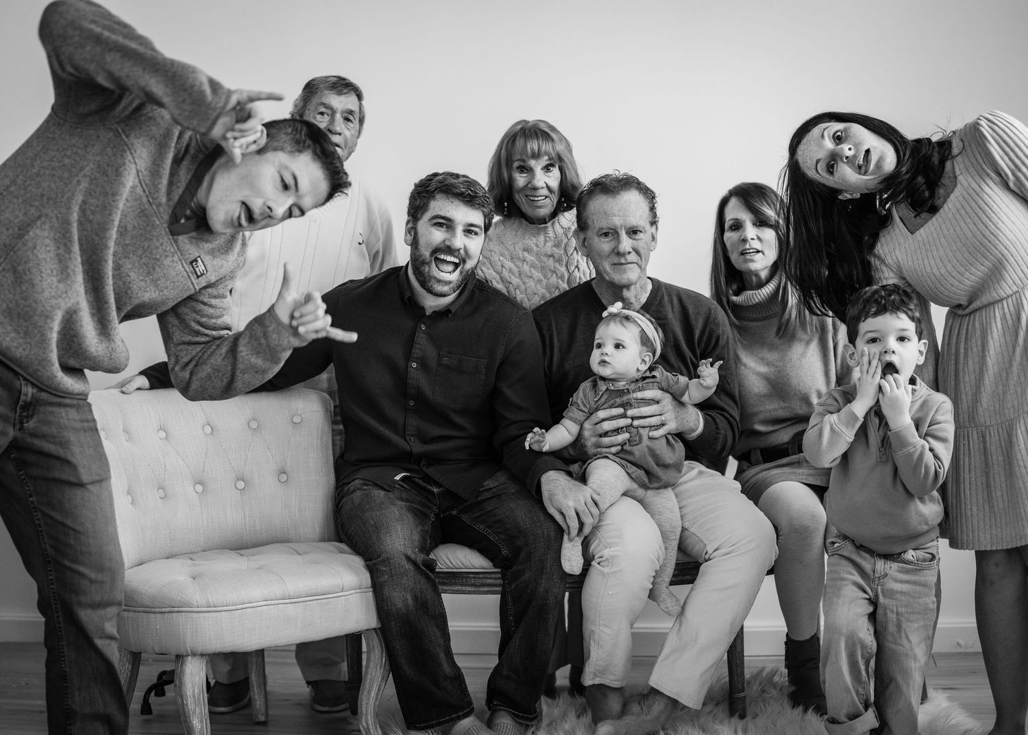 A black and white photo series showing a group sitting and laughing together on a couch.
