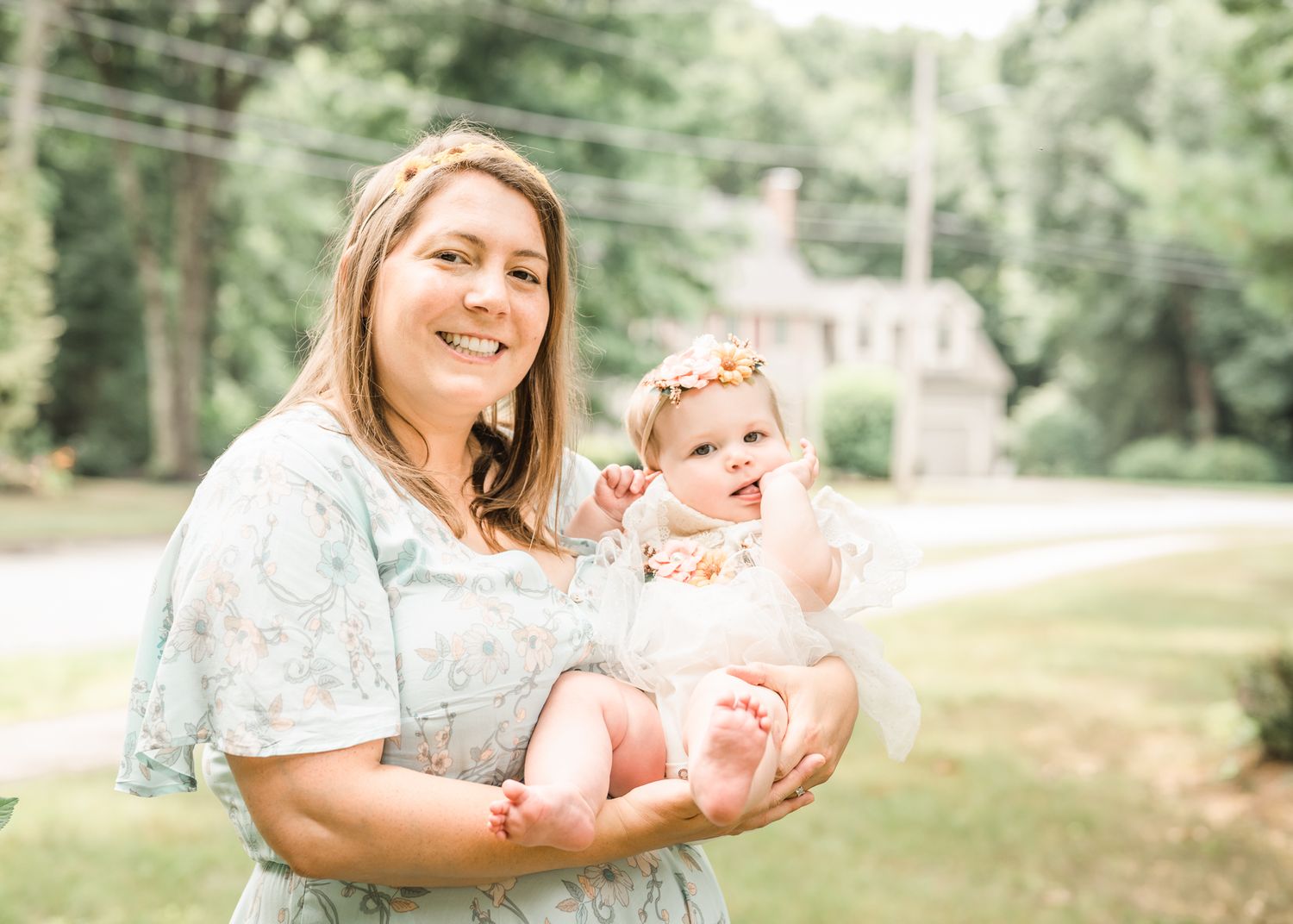Sunny outdoor portrait with house visible in wooded background.