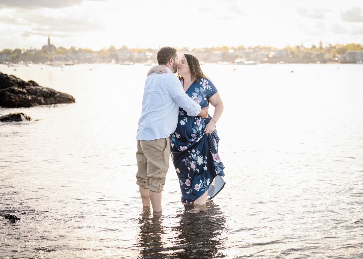 A couple wades in shallow ocean water during a romantic photoshoot.