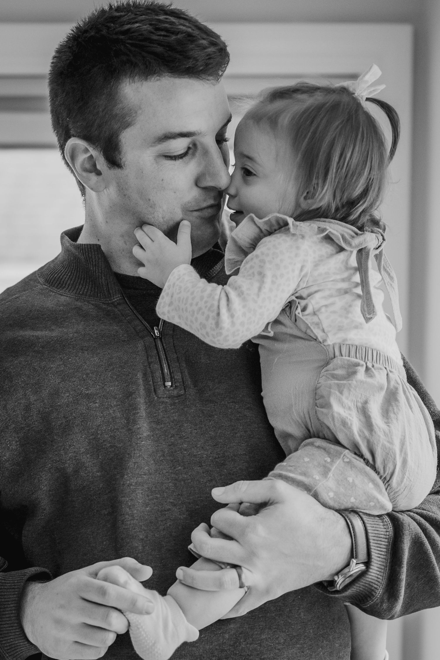 Tender moment captured in black and white between parent and child.