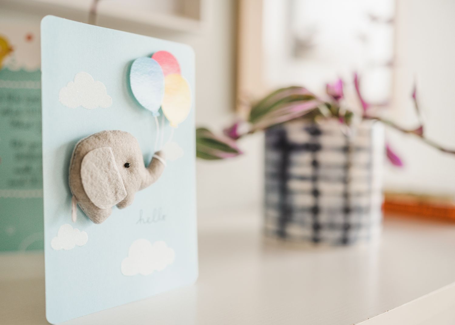 A cute baby elephant decoration card with pastel balloon design on light blue background.