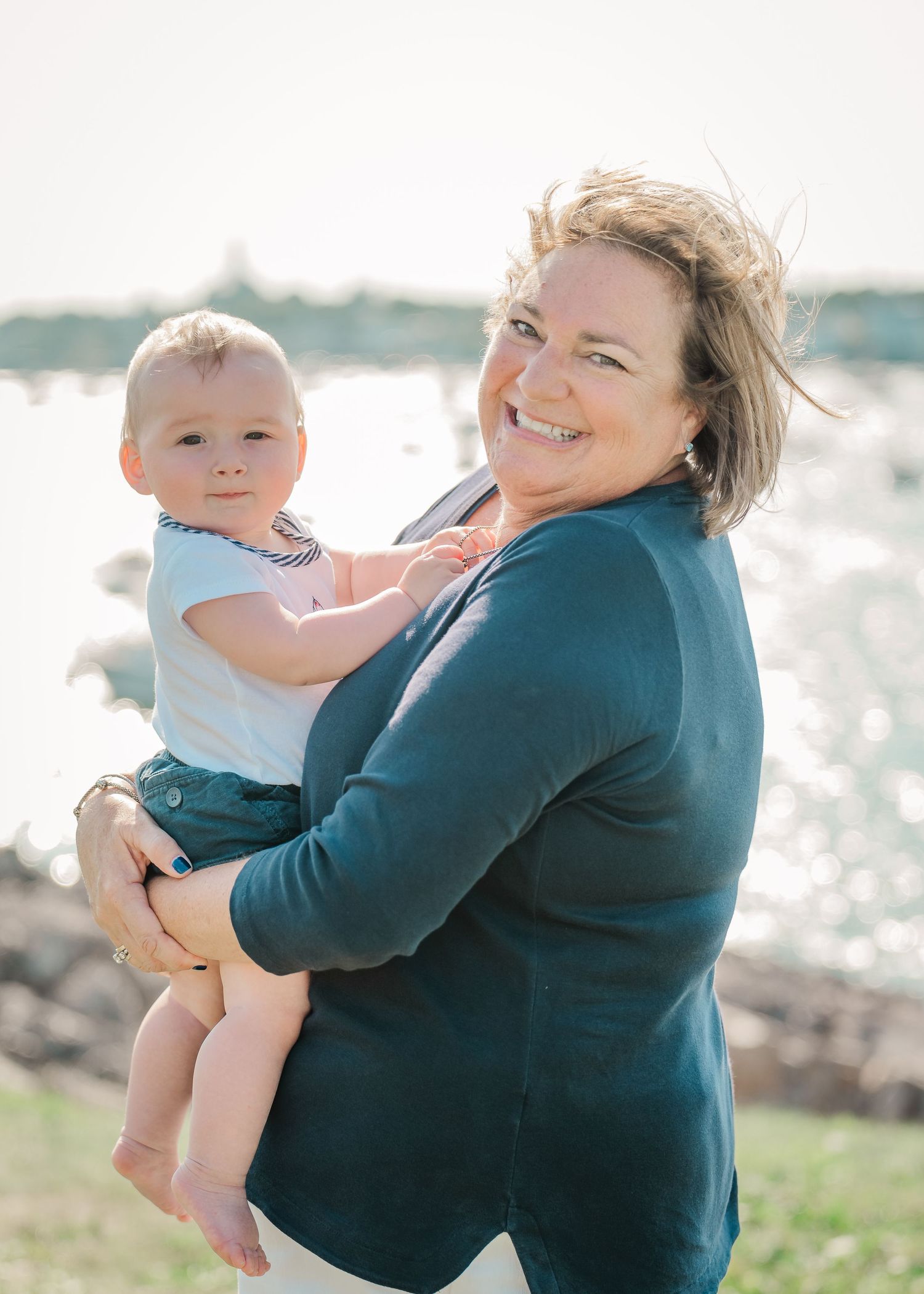 A sweet moment shared between parent and child near a waterfront on a bright sunny day.