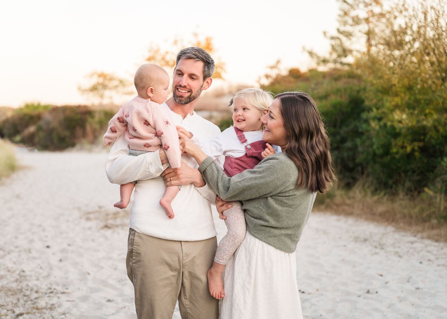A family enjoying golden hour together on a dirt path surrounded by nature.