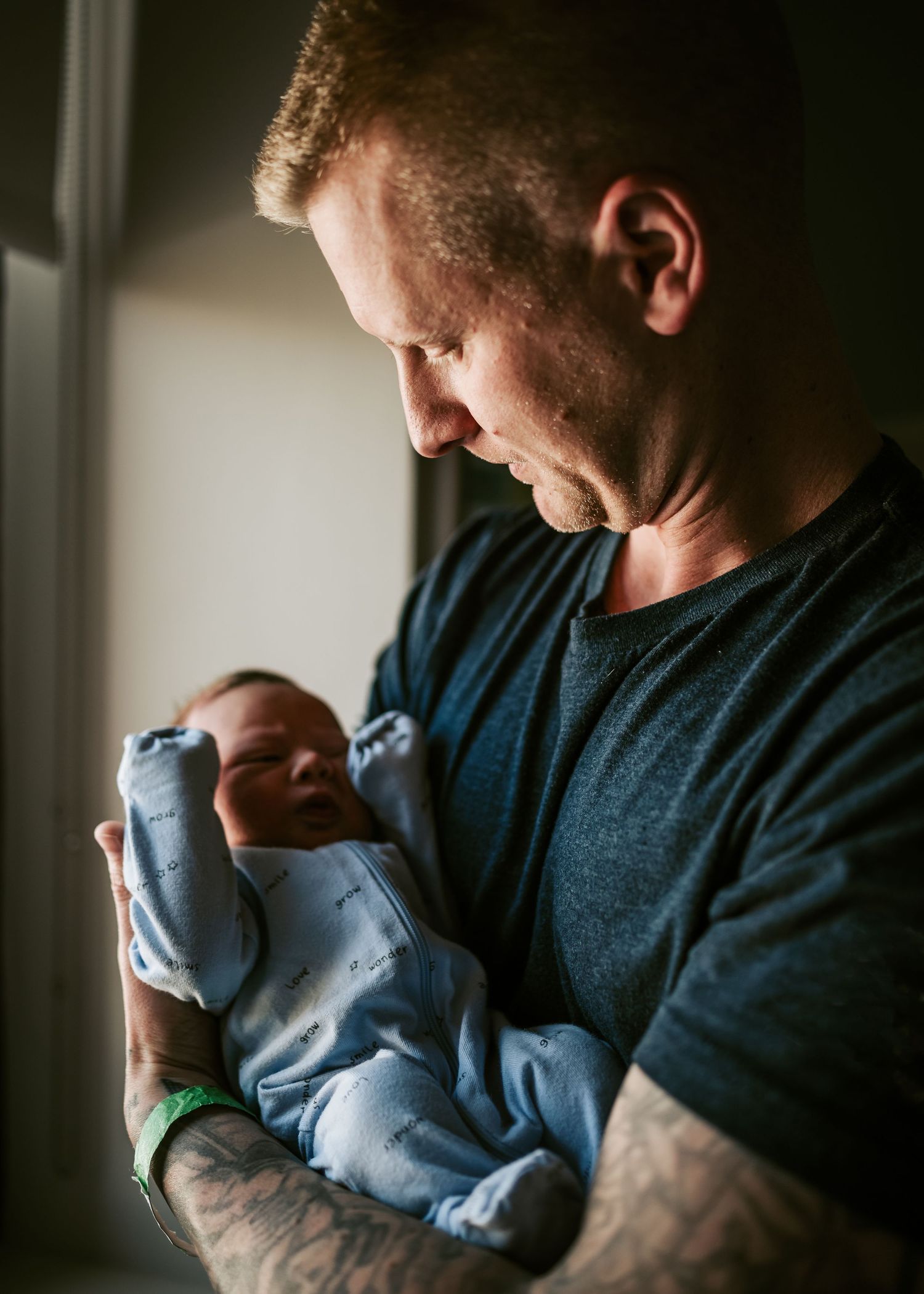 In soft lighting, a tender moment between parent and newborn.
