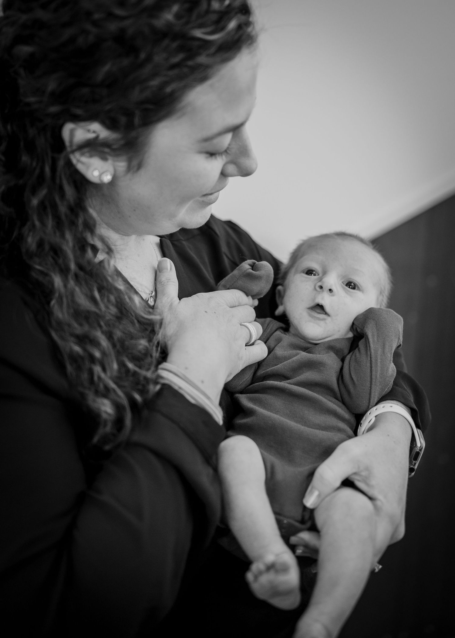 Tender black and white portrait of a baby and caregiver sharing a special moment.