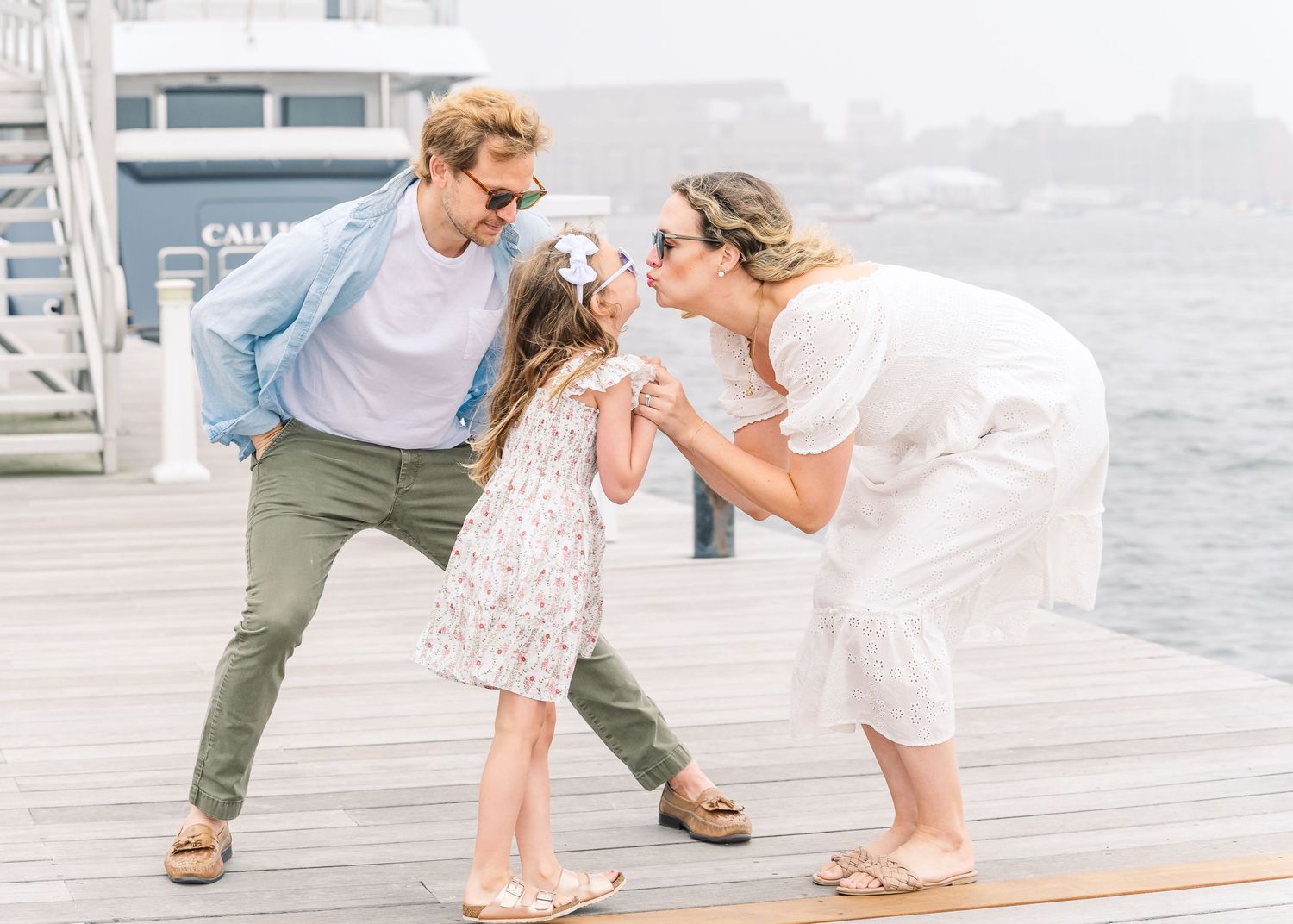 Candid moment of family fun and laughter on a seaside dock.