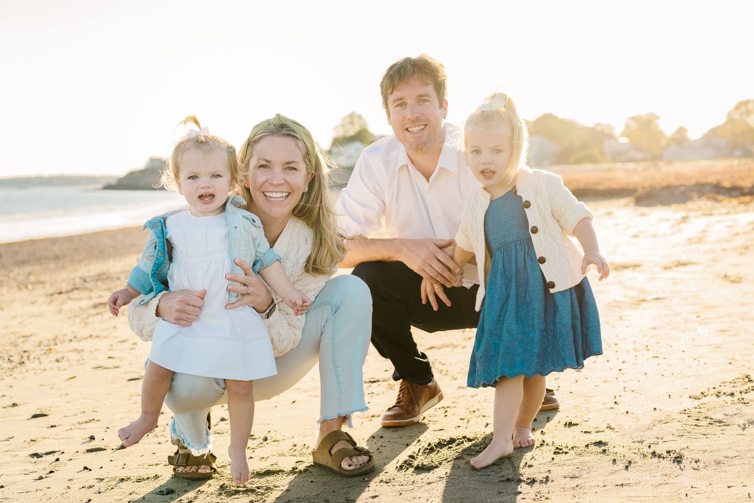 Family enjoying a sunset photoshoot together on a beautiful beach.