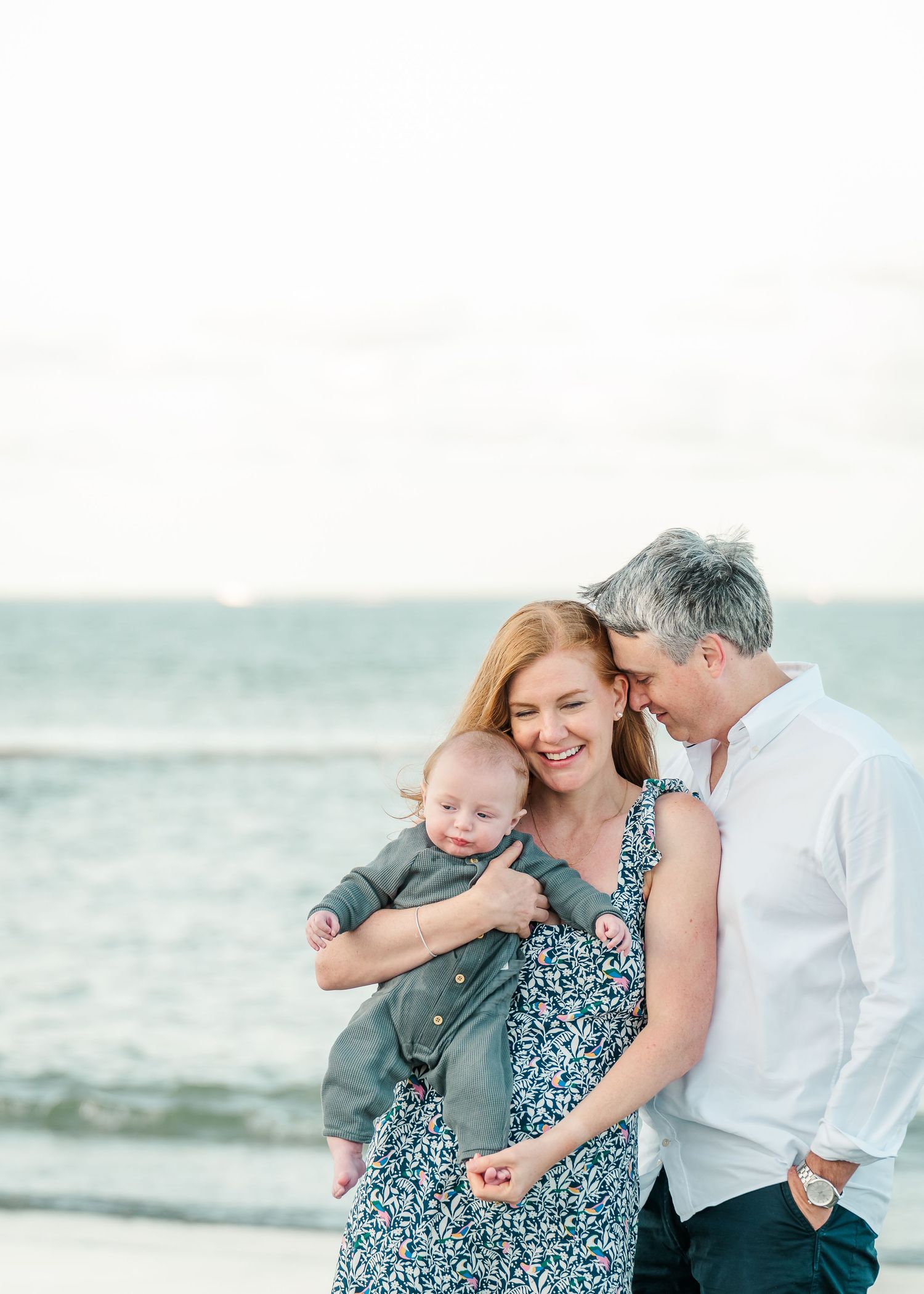 A serene beach portrait with the ocean waves creating a peaceful backdrop for a family moment.