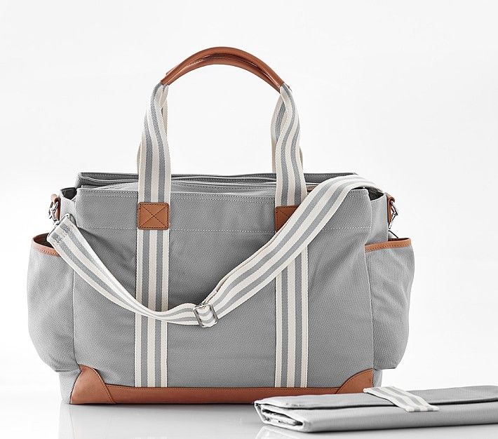 Gray canvas diaper bag with white stripes and brown leather trim featuring multiple compartments.