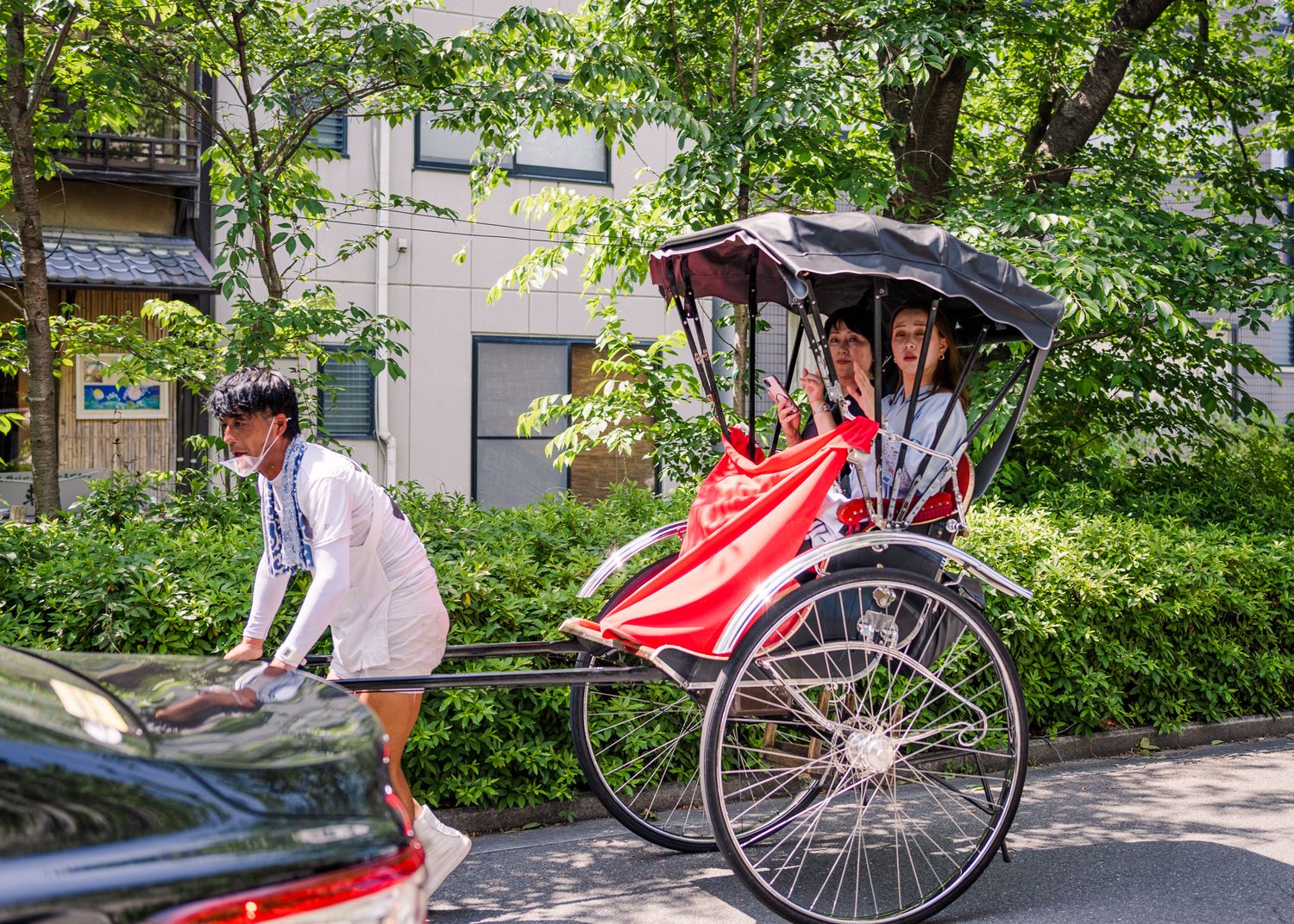 Traditional rickshaw with red blanket parked on a street in Japan.