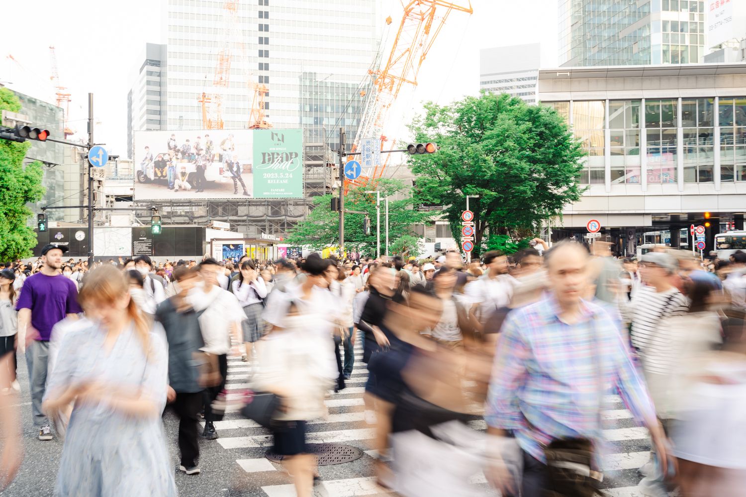 Busy street crossing in Tokyo with motion-blurred pedestrians during rush hour.