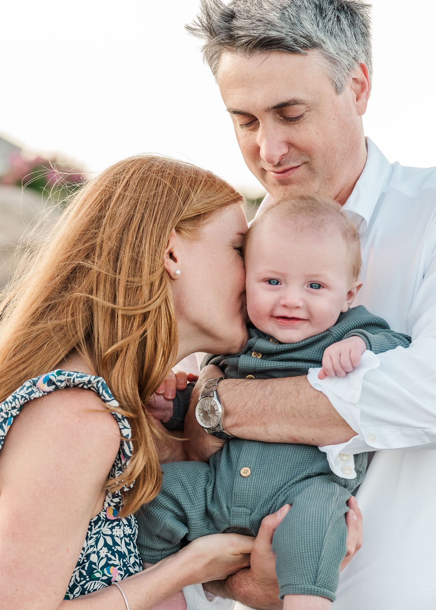An intimate family moment captured on the beach during a sunset photo session.