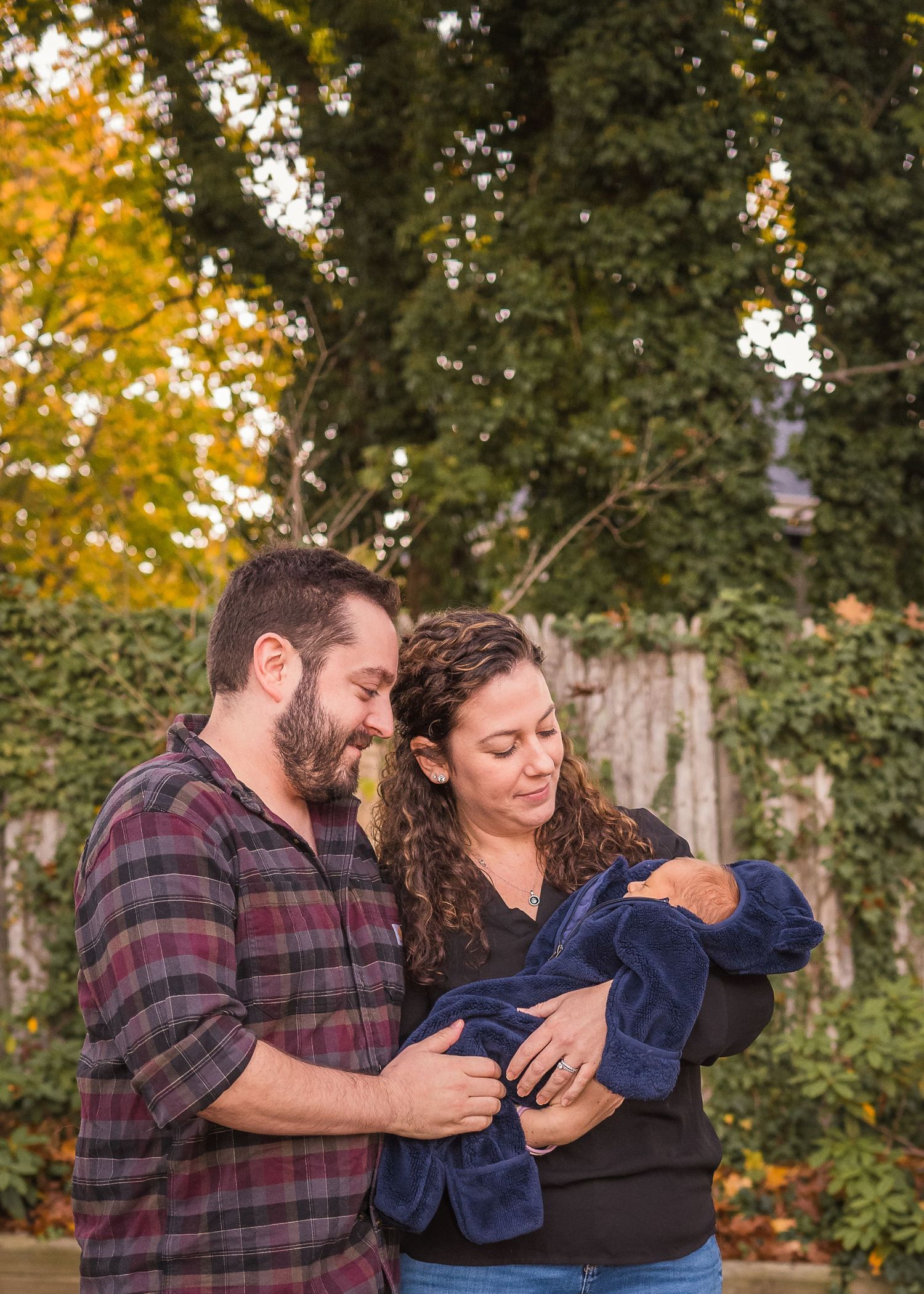 Family enjoying an autumn moment together in front of fall foliage.