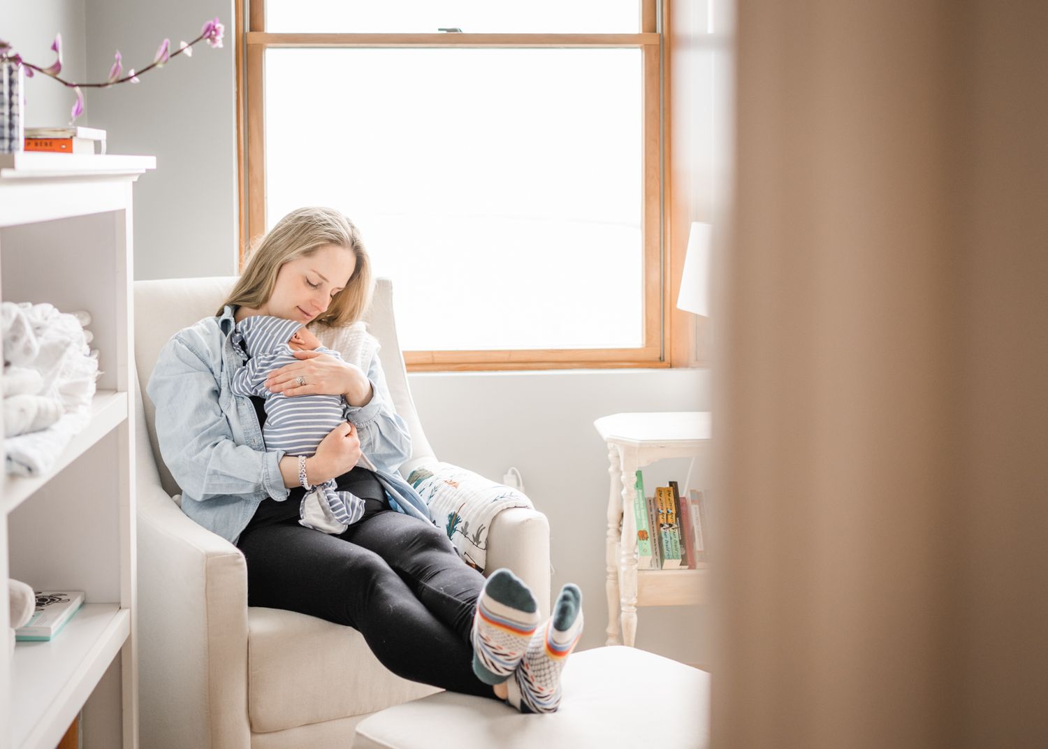 Cozy nursery scene with sleeping baby in comfortable armchair.