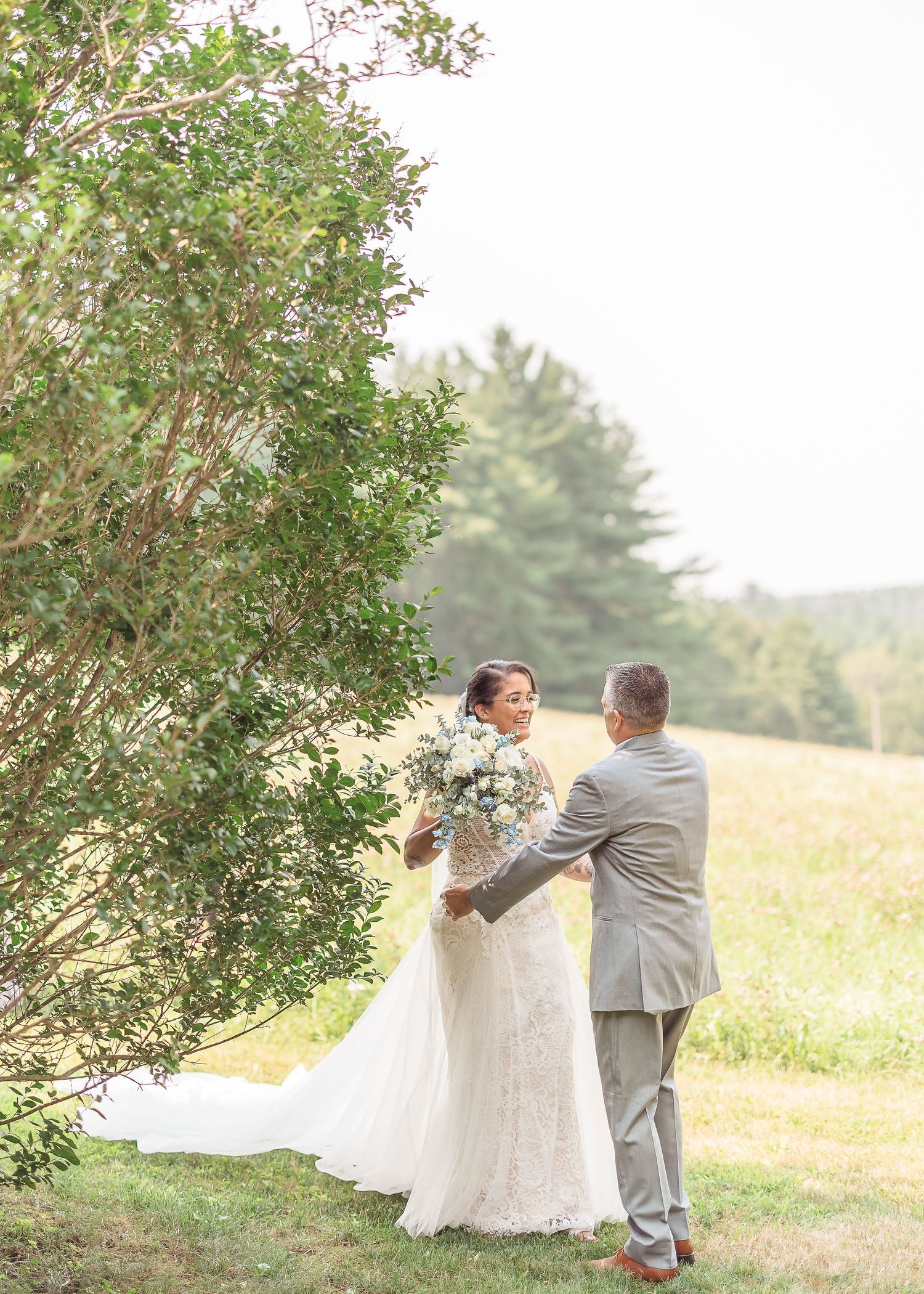 Couple swirling and twirling in a picturesque outdoor field with the bride's dress flowing in the breeze.