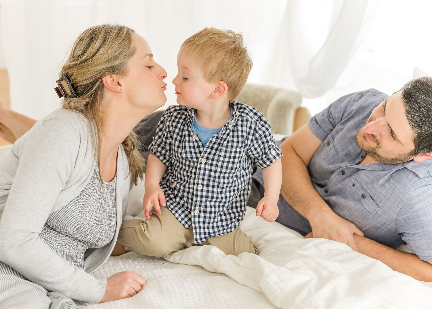 A sweet family moment of playful interaction while relaxing together on a bed.