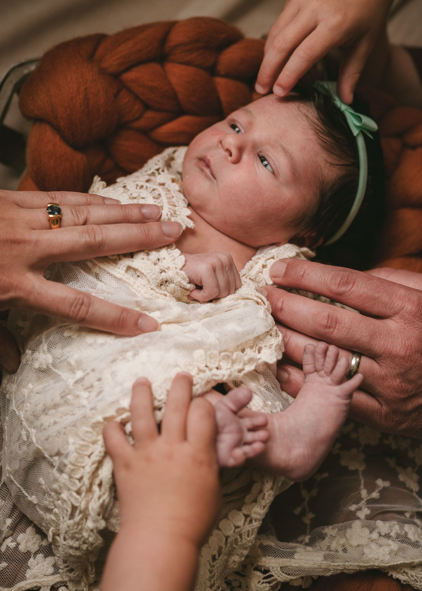 Intimate portrait of caring moment with baby on brown knit blanket.