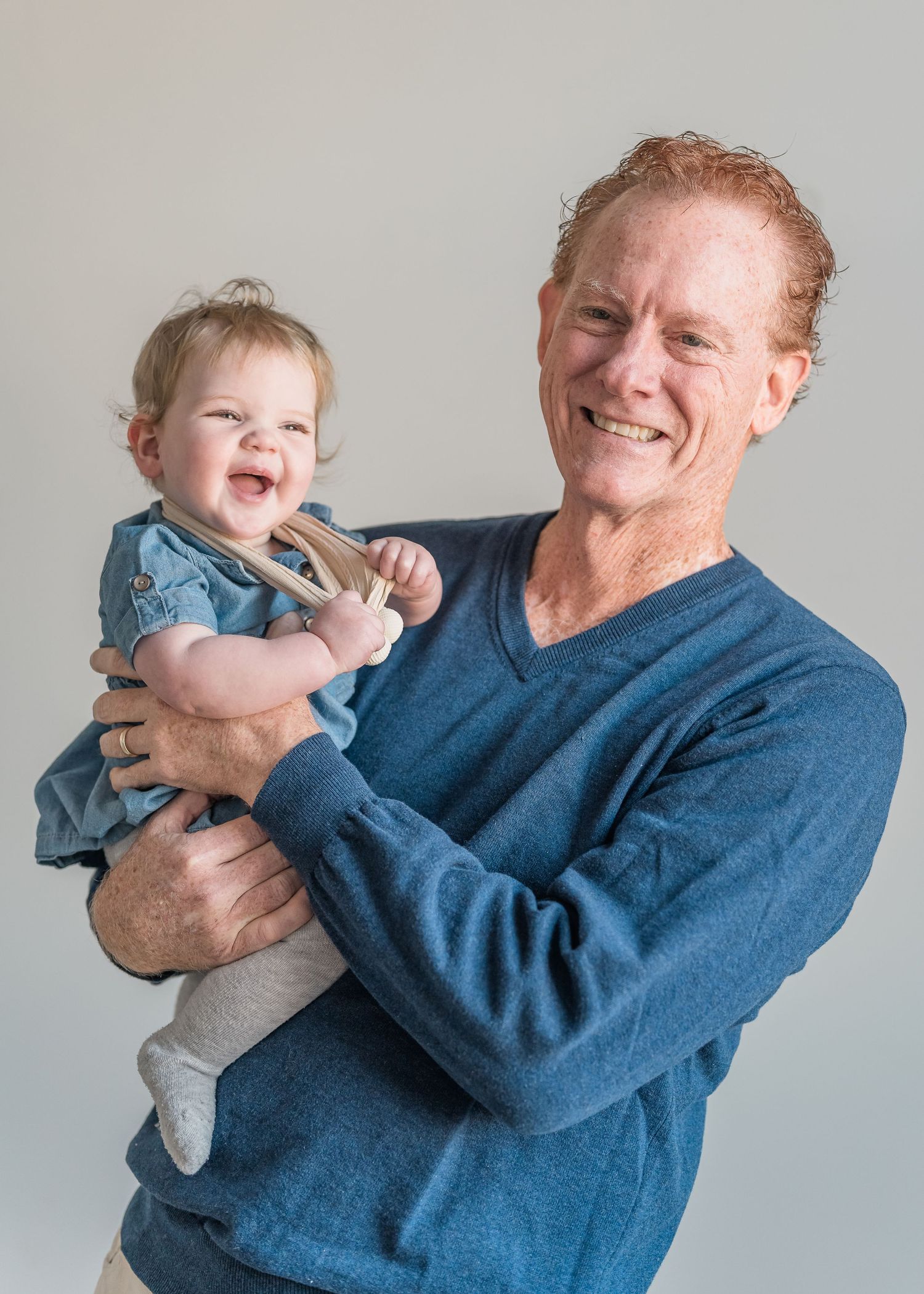 A playful sequence shows a person in a blue sweater swinging and playing with a laughing toddler in light clothing.
