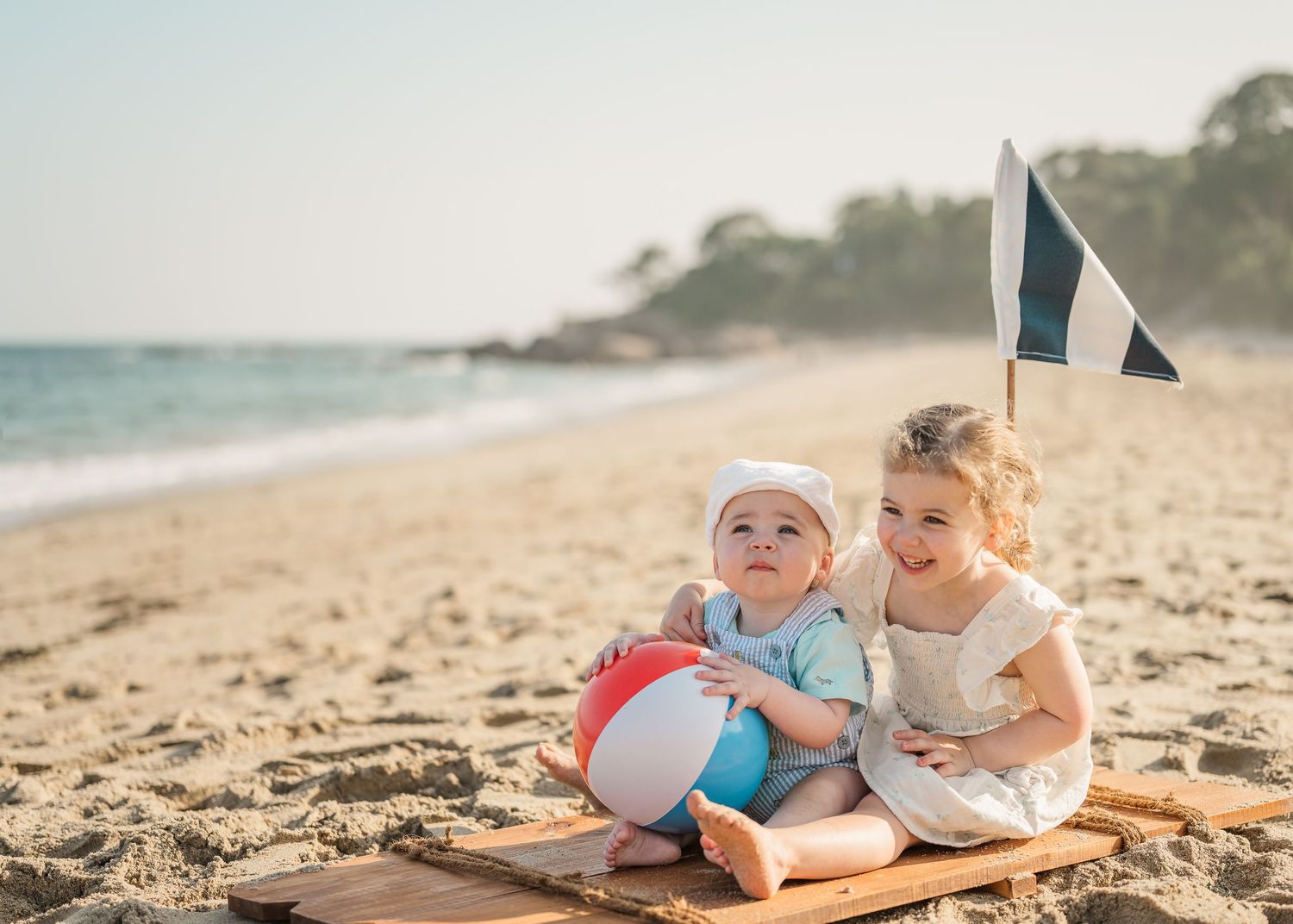 Children playing together on a sandy beach with a beach ball on a sunny summer day.