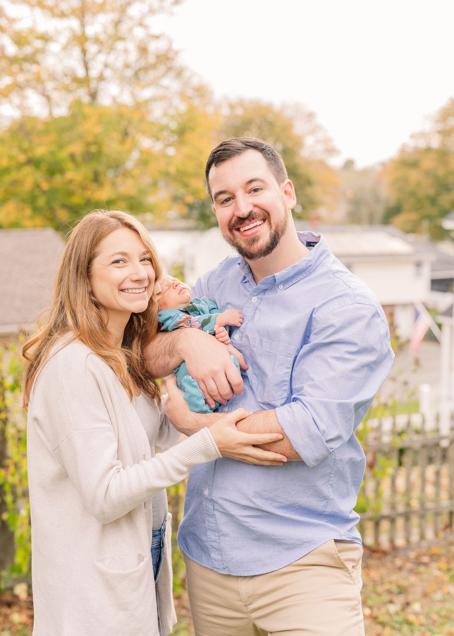 Family portrait outdoors in autumn with fall foliage background.