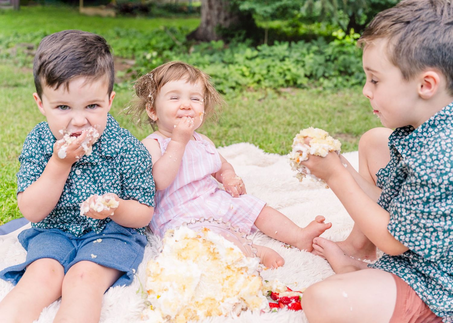 Children enjoying cake and treats at outdoor picnic.