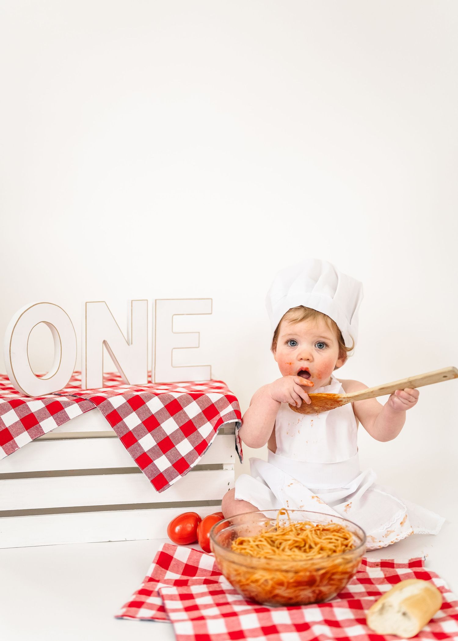 Spaghetti Smash. A child in a chef's hat and apron excitedly tastes spaghetti sauce from a wooden spoon in a bright kitchen setting.