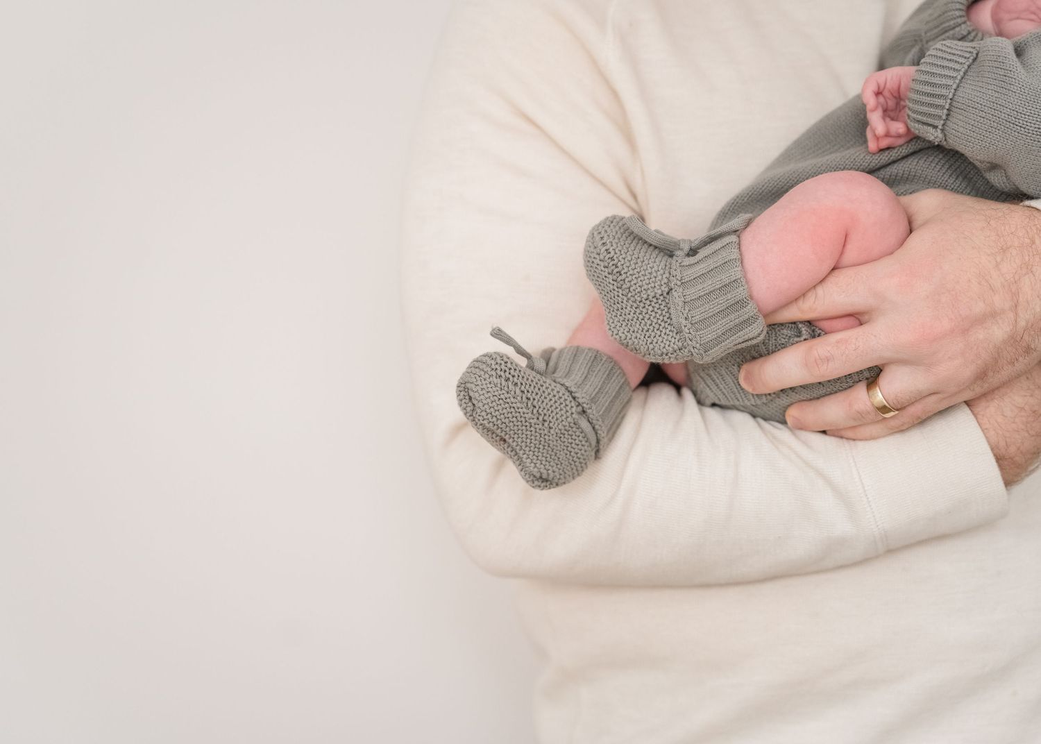 Series showing baby in gray outfit lying on soft white bedding.