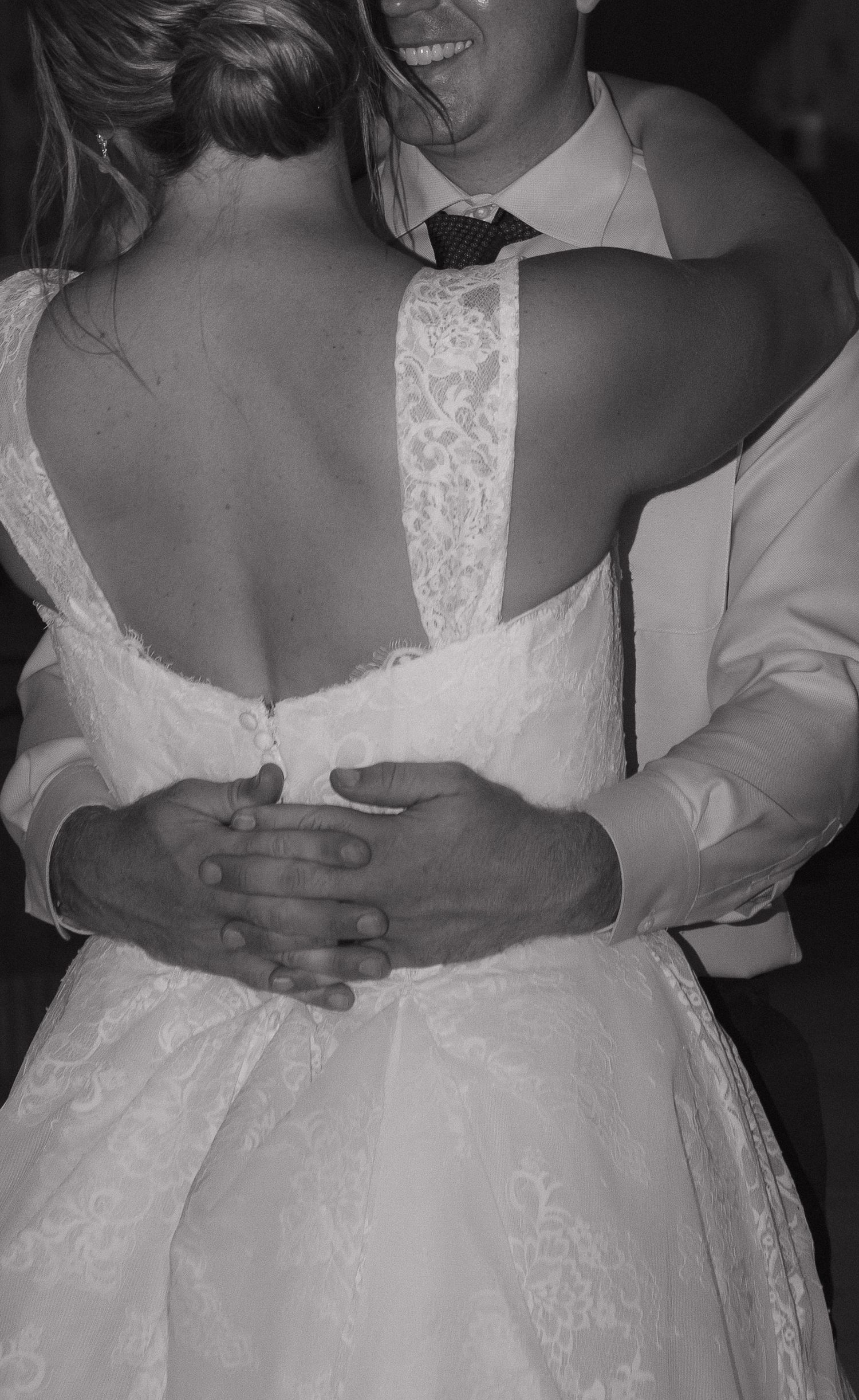 A black and white image of a couple embracing at what appears to be a formal event, such as a wedding.