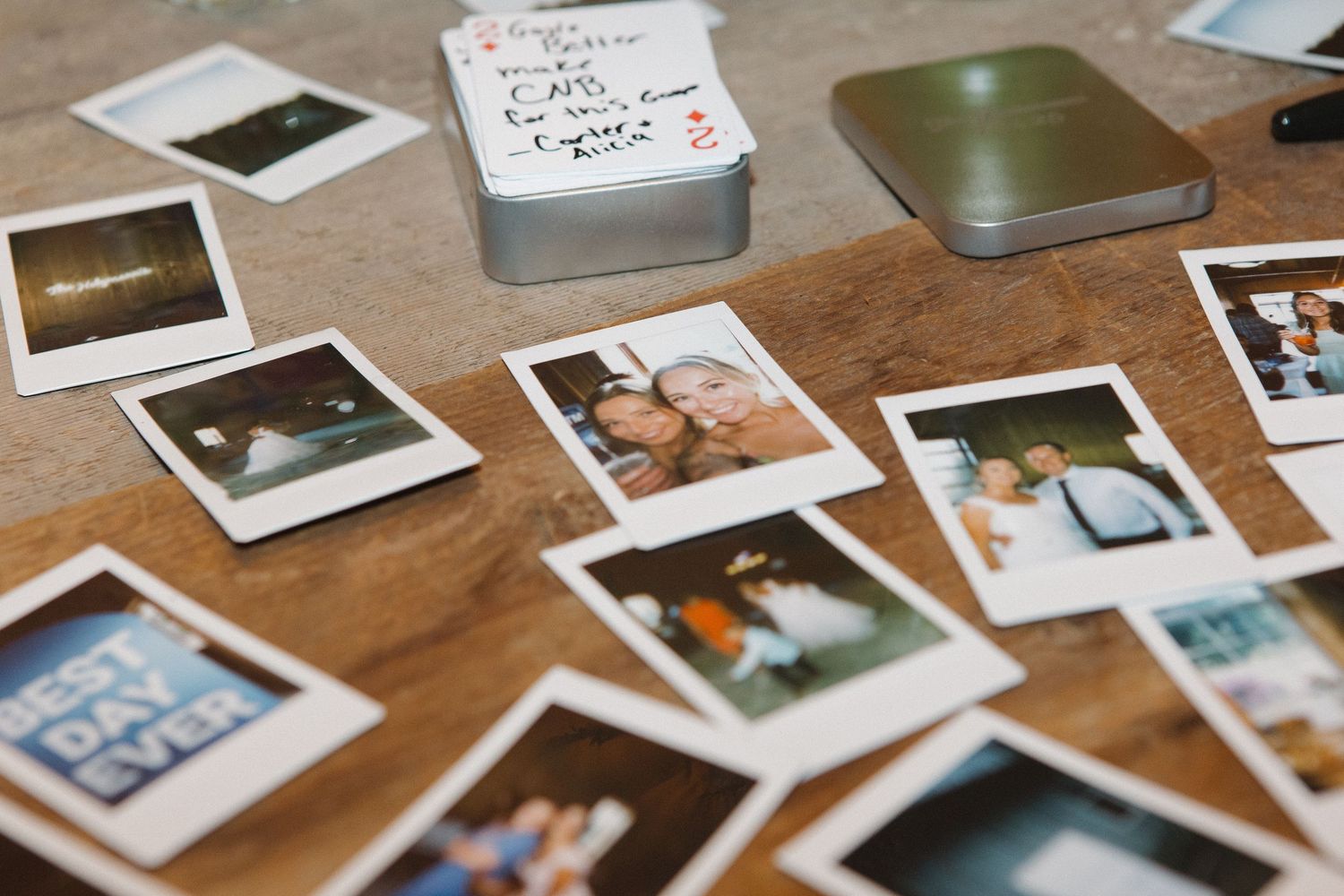 A collection of polaroid-style photographs scattered on a wooden surface.