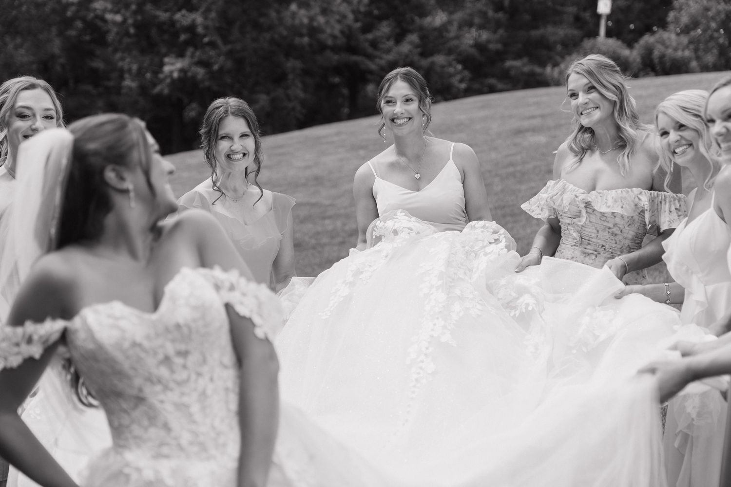 A group of women in formal dresses posing together outdoors.