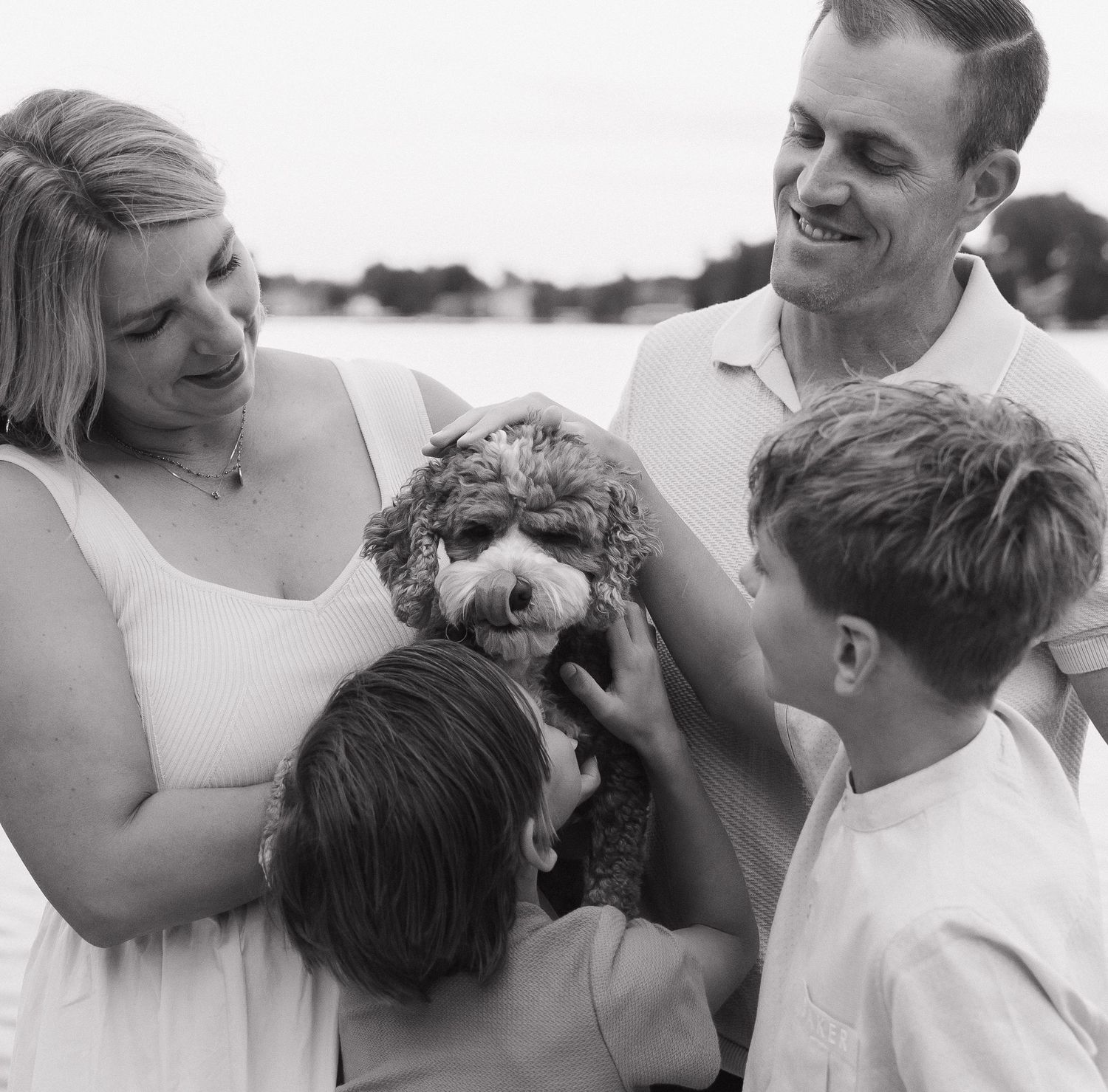 A family enjoying a sunny day outdoors, with a dog and two children in the scene.