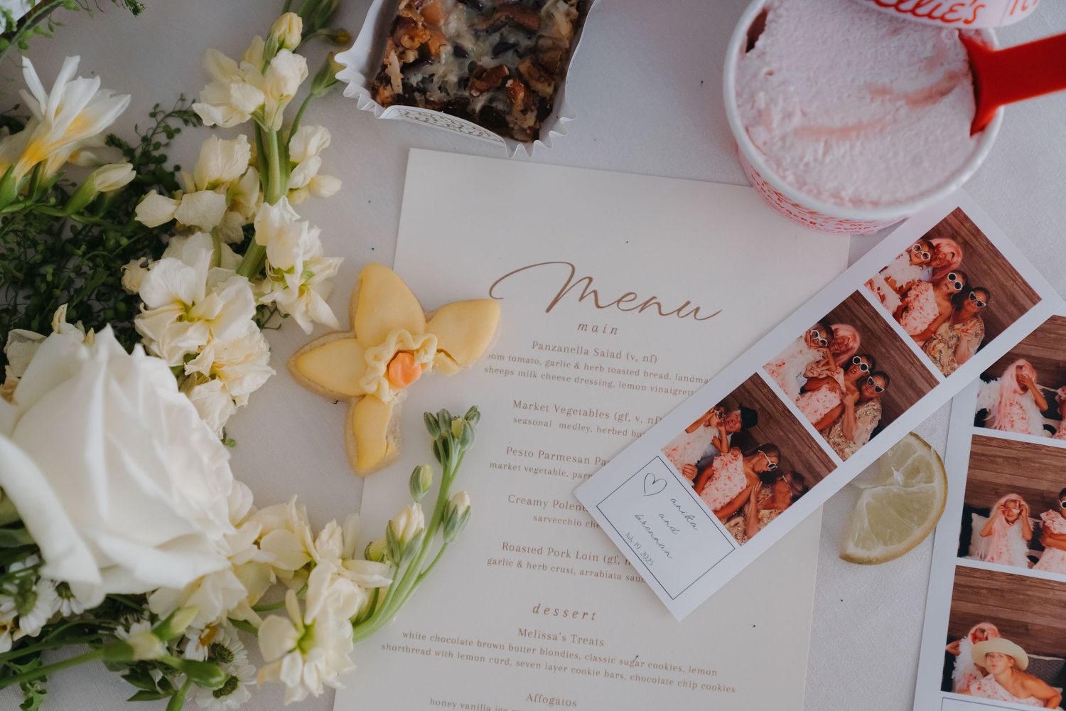 A floral arrangement with white flowers and a menu on a table, showcasing a wedding or event setting.