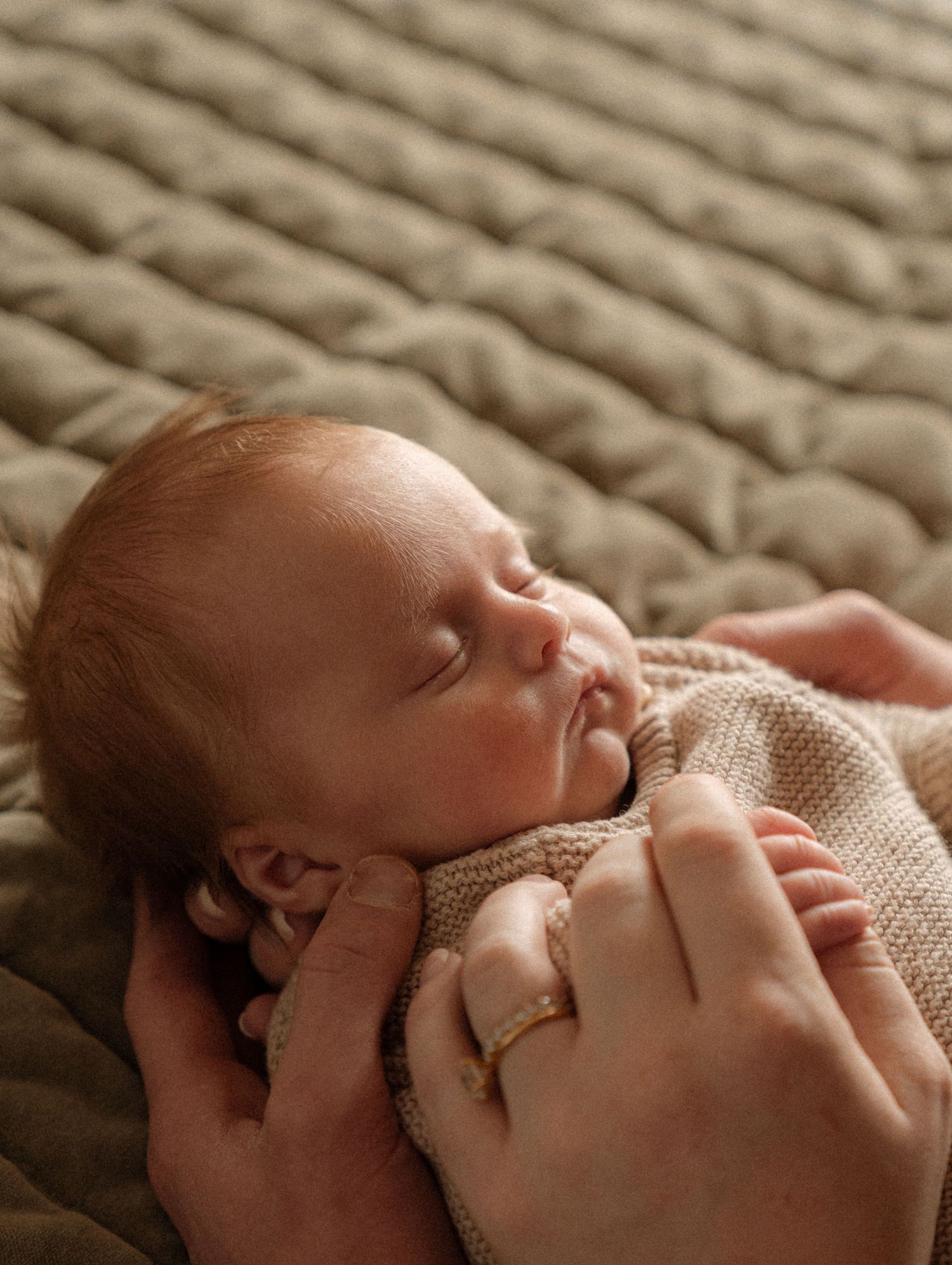 A newborn baby sleeping peacefully wrapped in a soft blanket.