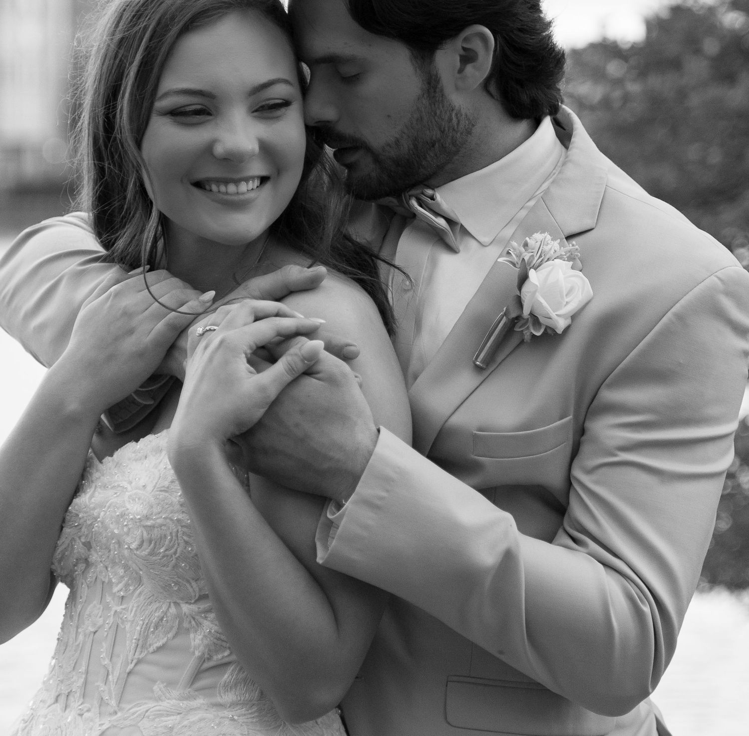 A happy bride and groom embrace and smile affectionately on their wedding day.