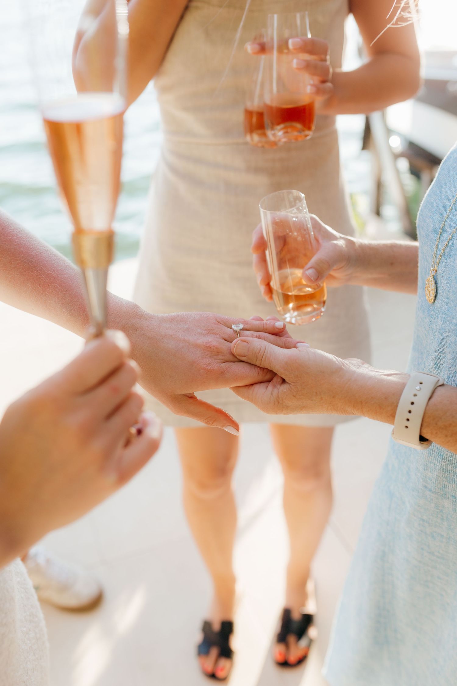 The image shows a group of people holding glasses of alcoholic drinks, likely celebrating or socializing.