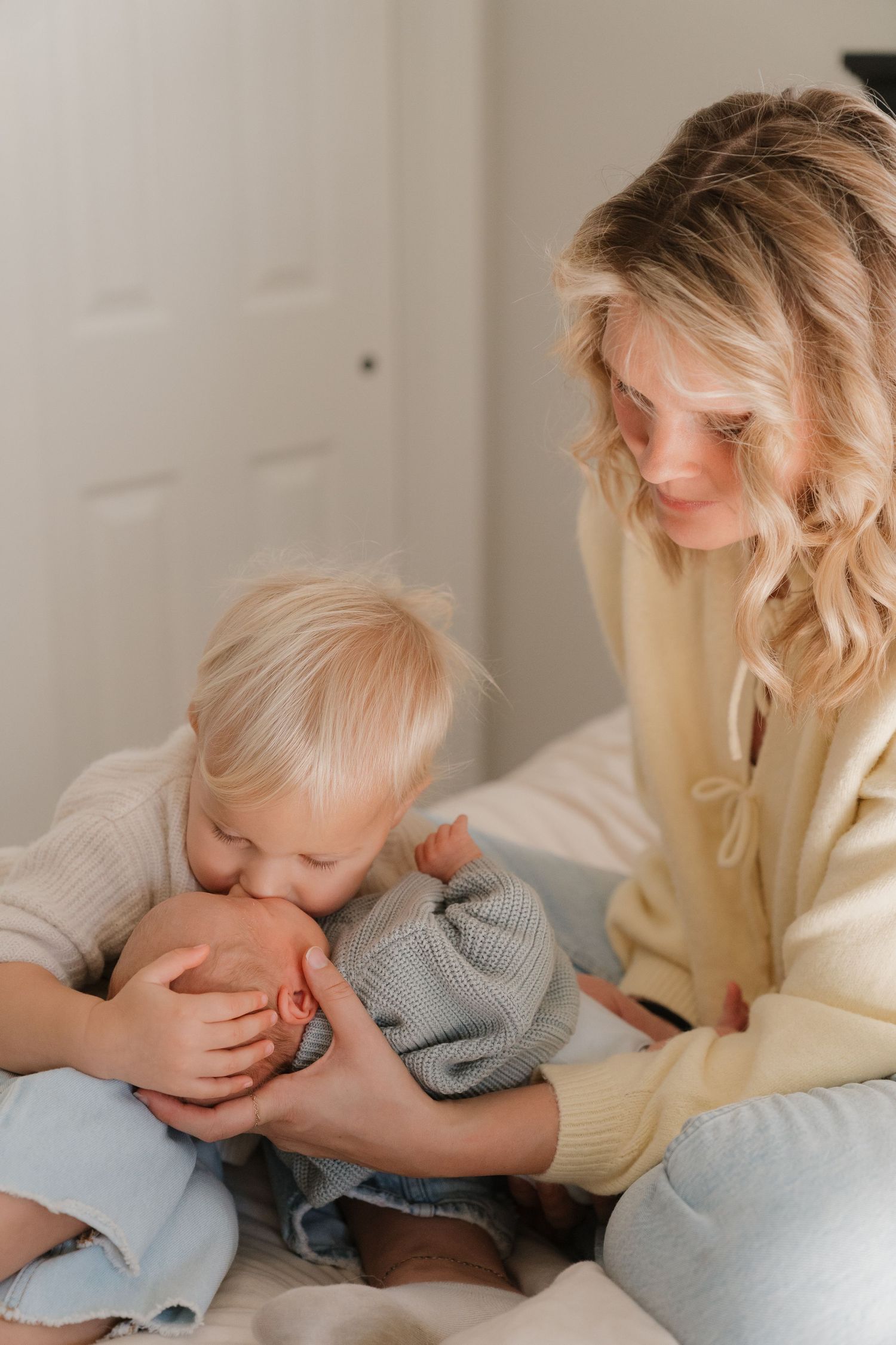 A mother gently holds her young child in a warm embrace, creating a tender moment of affection and care.