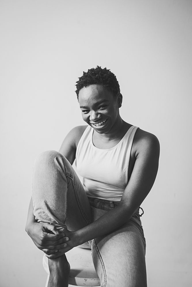 Black and white portrait series showing a person in a tank top holding their stomach while laughing.