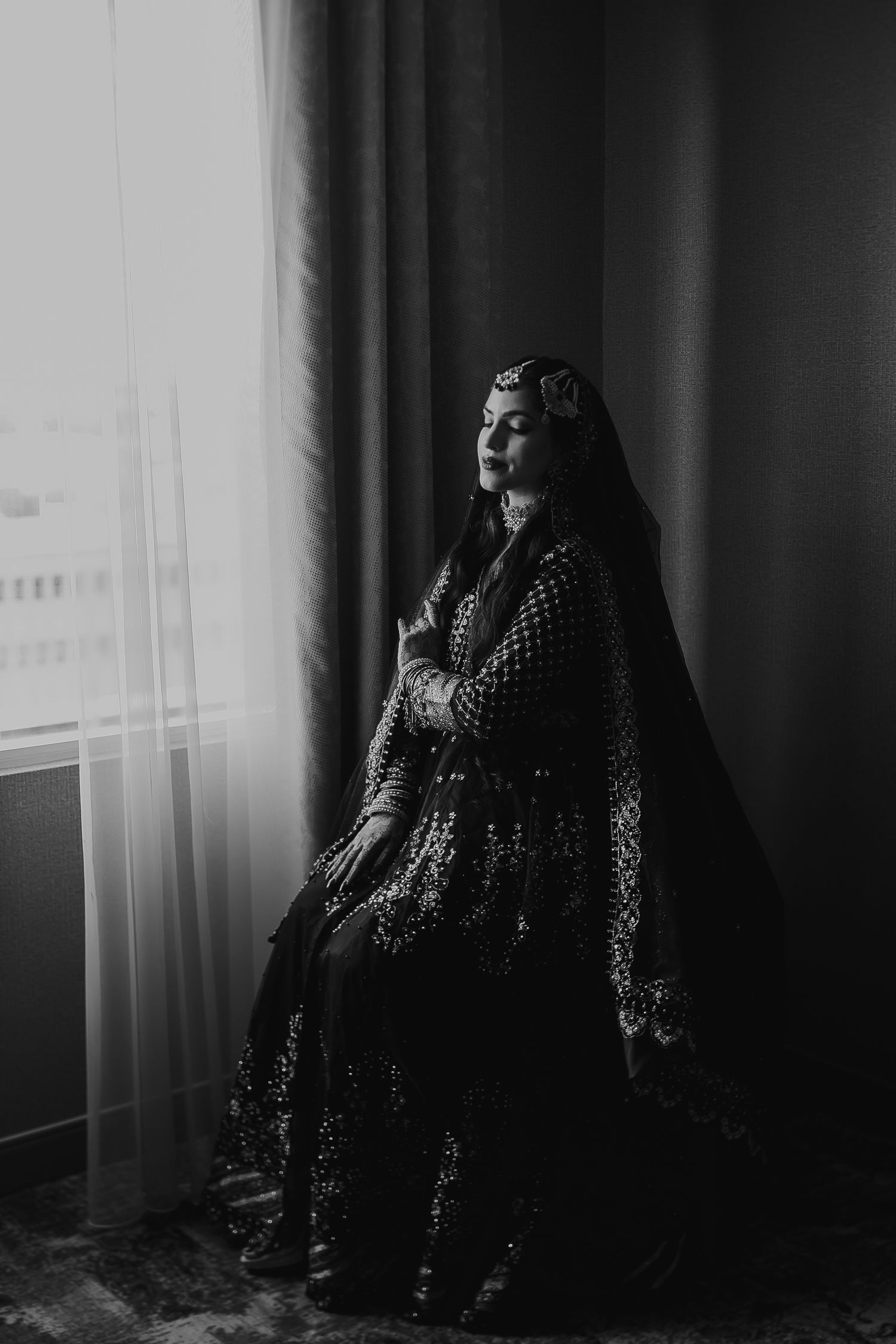 A dramatic black and white photo series showing a figure in a polka dot dress moving through moody window light.