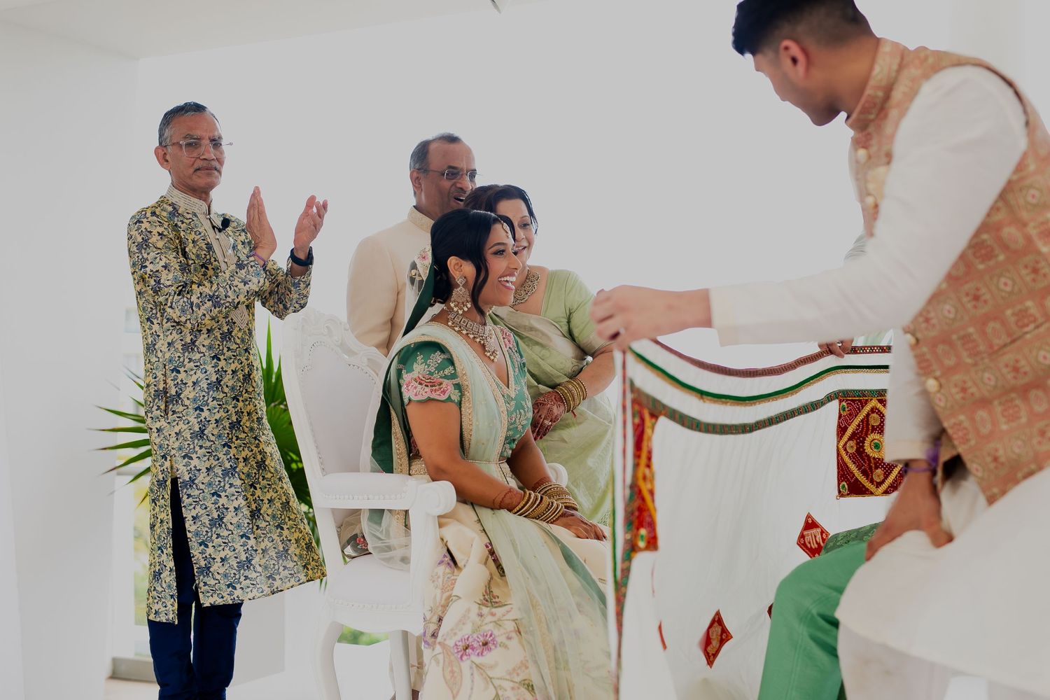 A traditional ceremony showing guests presenting a decorated cloth during wedding rituals.