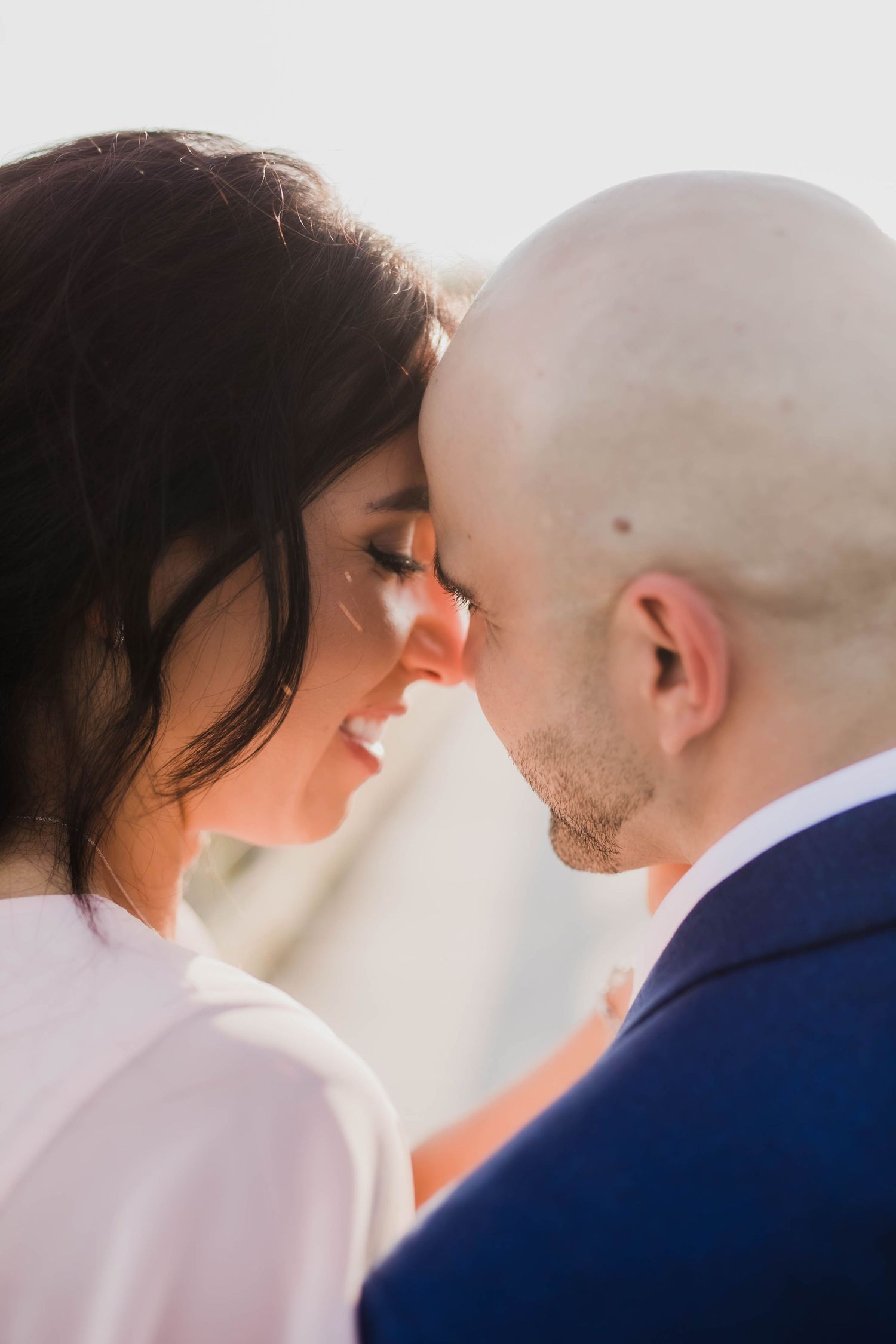 A romantic close-up sequence showing a couple touching foreheads and sharing intimate moments against a light background.