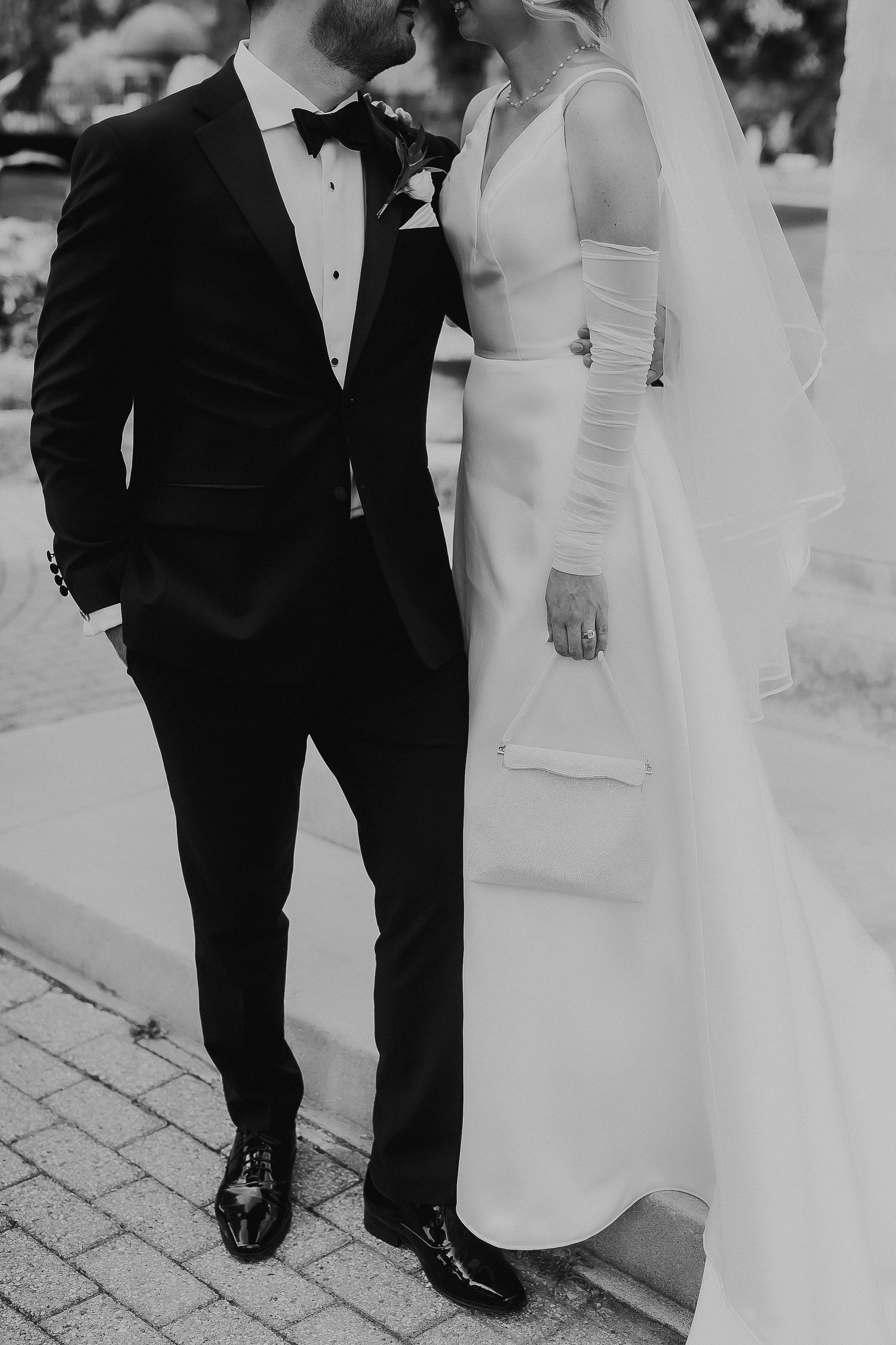 Elegant black and white wedding portrait showing formal attire details.