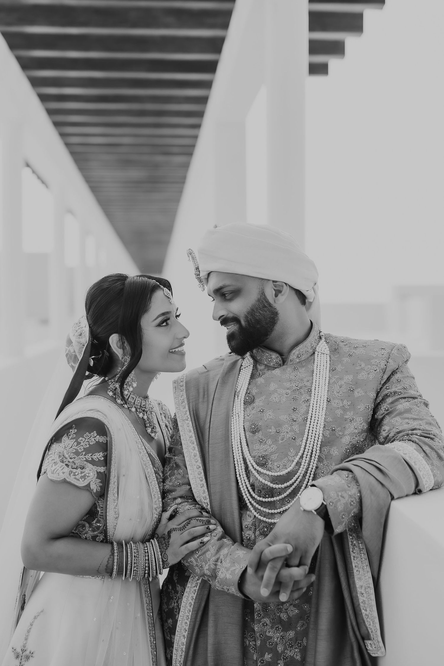 Black and white portrait of a couple in ornate wedding attire in a modern corridor.Windsor/essex and destination wedding and portrait photog