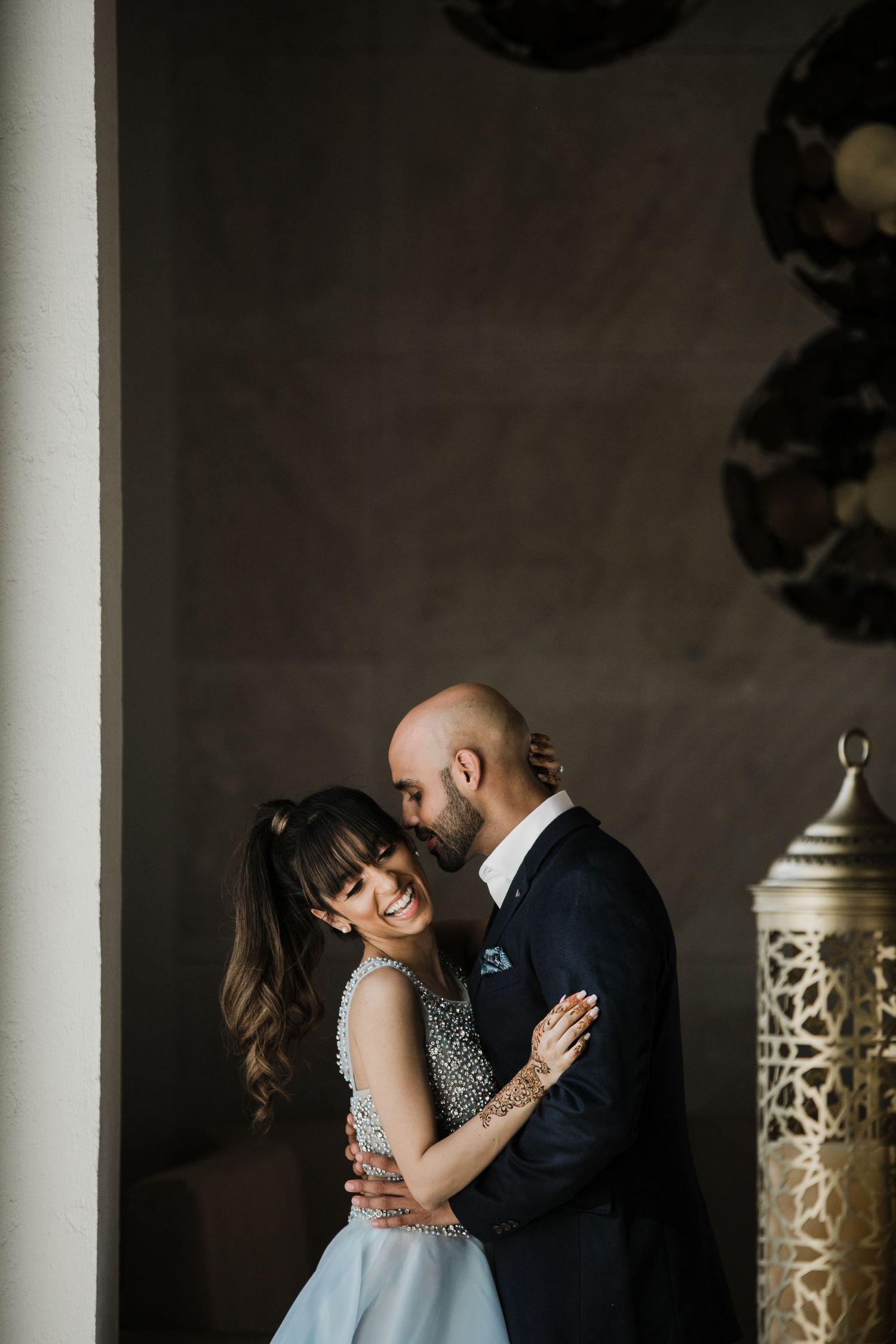 A romantic moment captured in moody lighting as a couple embraces in formal attire.
