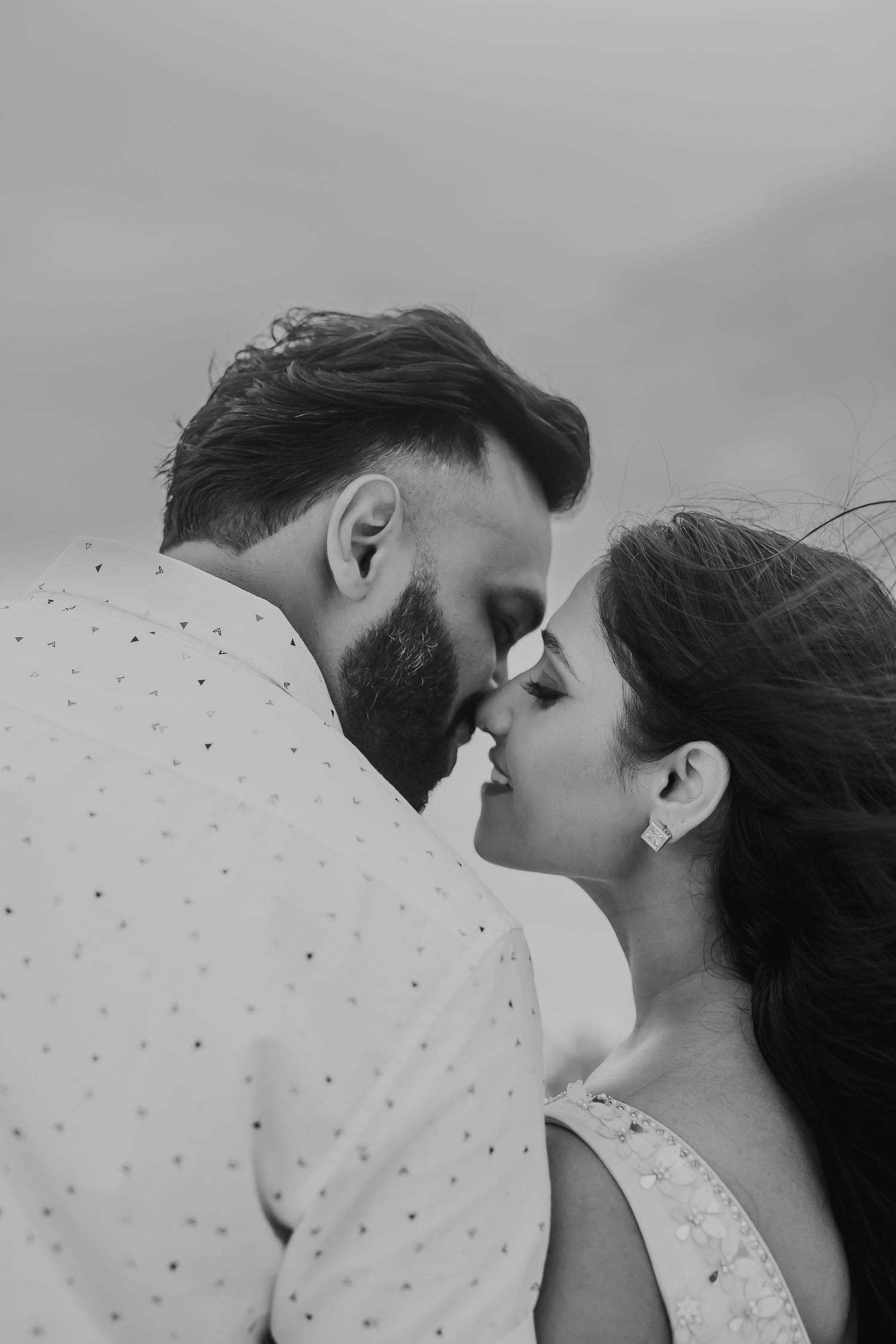 An intimate black and white portrait of a couple sharing a romantic moment.