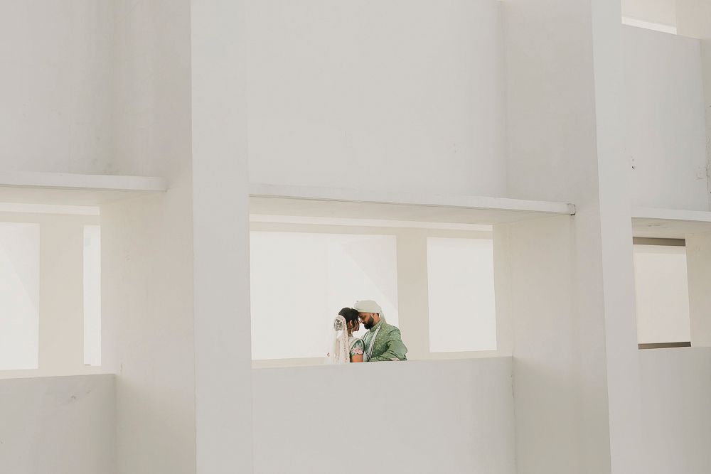 Modern minimalist white interior with built-in wall shelves and clean lines.